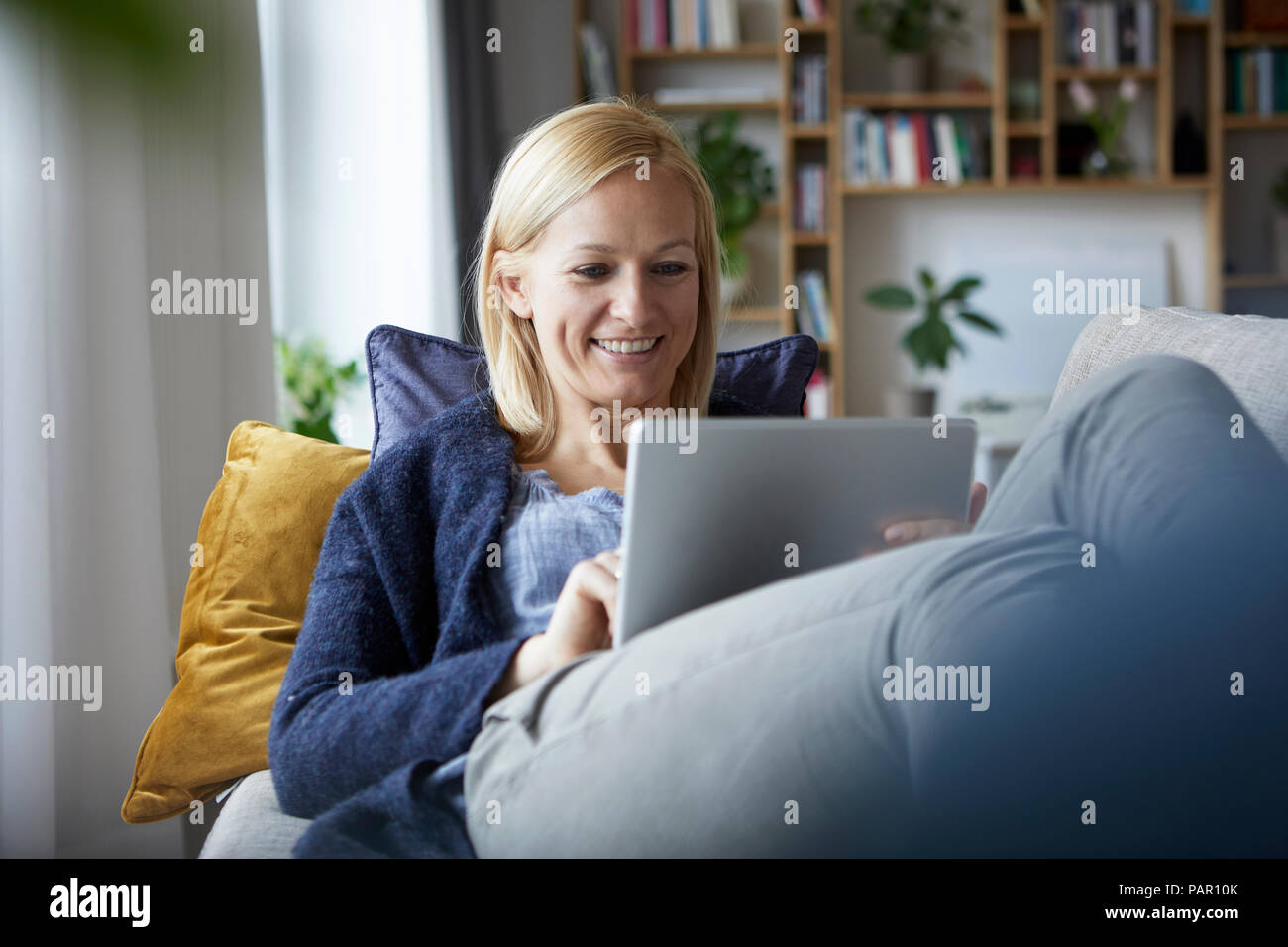 Frau mit digitalen Tablet, Relaxen auf der Couch Stockfoto