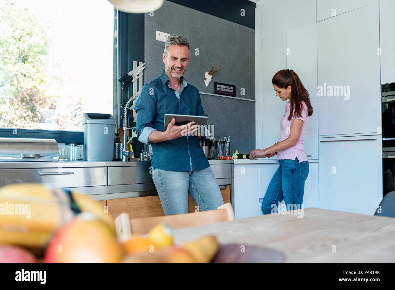 Paar in der Küche zu Hause kochen und mit einem Tablet Stockfoto