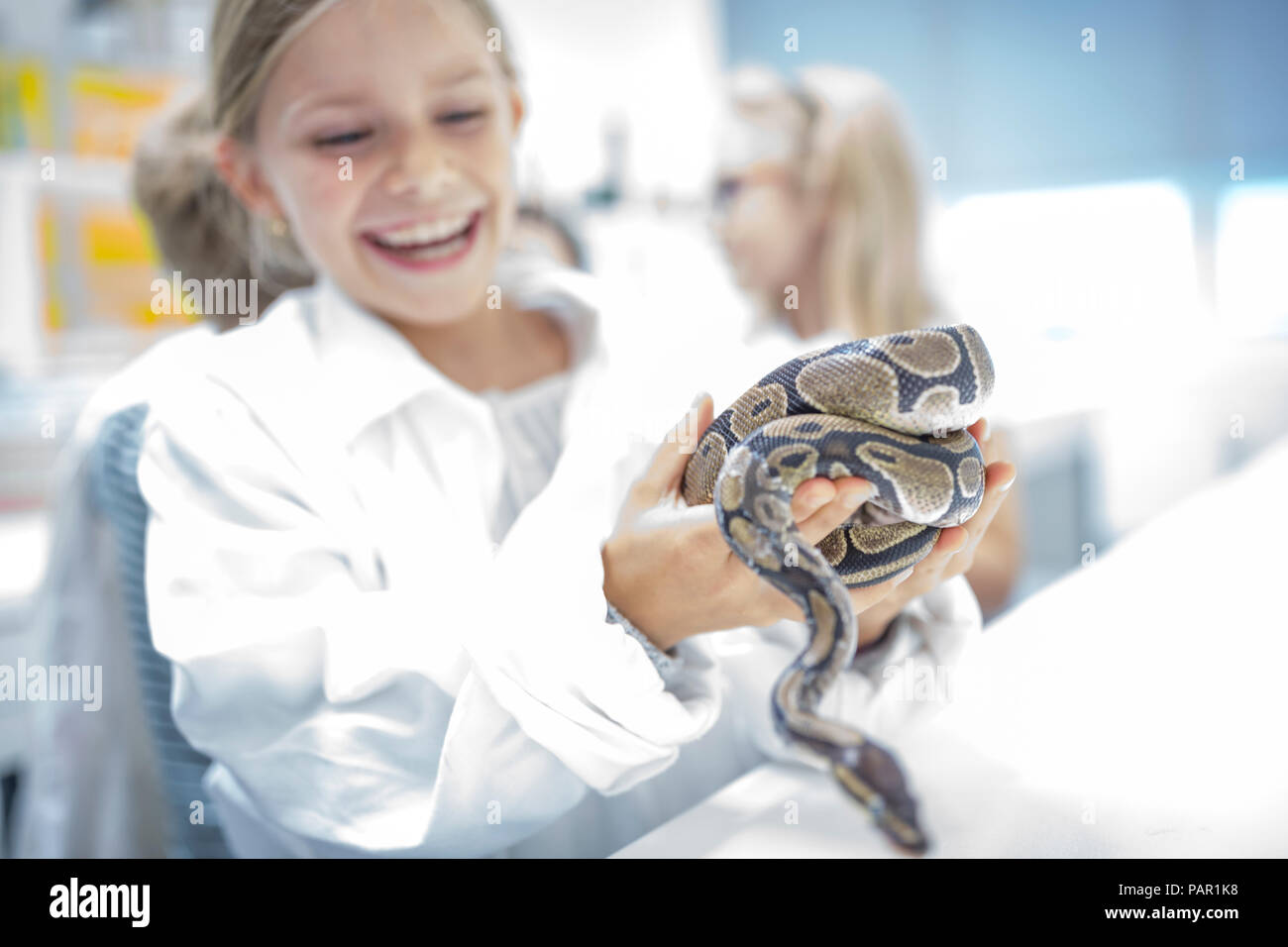 Glückliche Schülerin in Wissenschaft Kategorie holding Schlange Stockfoto