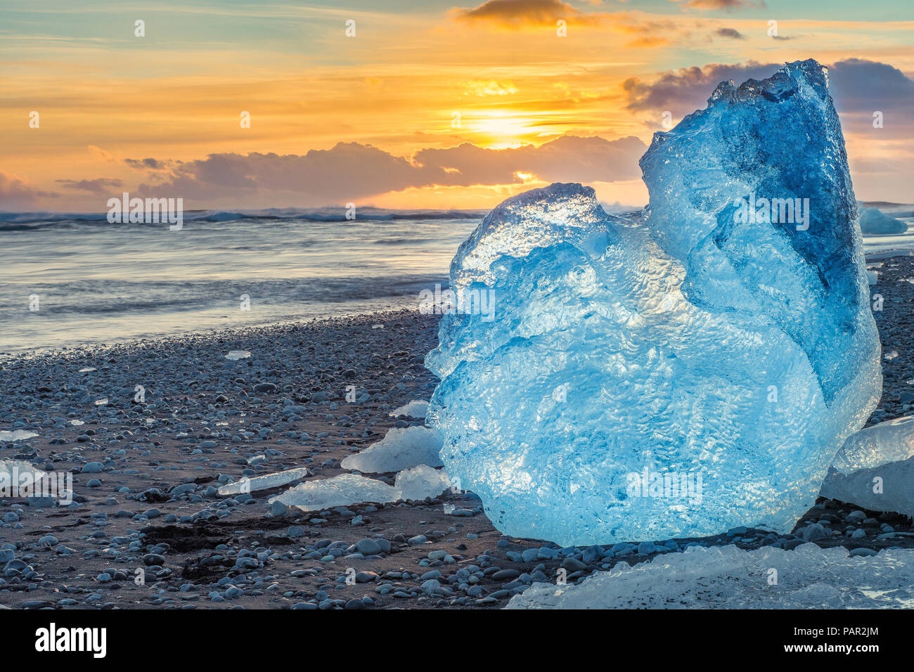 Die Sonne über dem Atlantik Ausleuchten der berühmten Eisberge auf Diamond Beach, die bei der Öffnung der Gletscherlagune Jökulsárlón Stockfoto