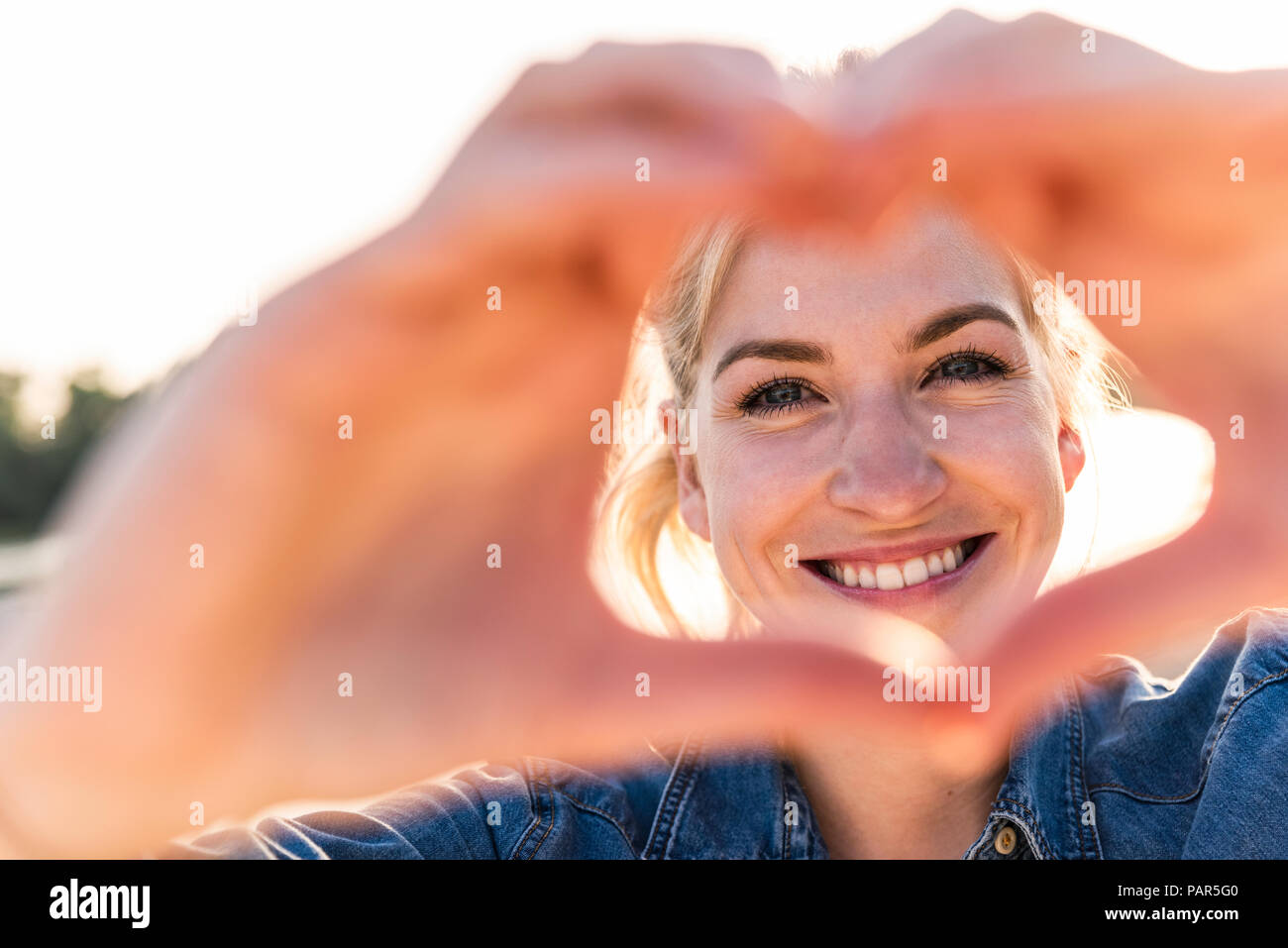 Frau, die Herzform mit Händen und Fingern. Stockfoto