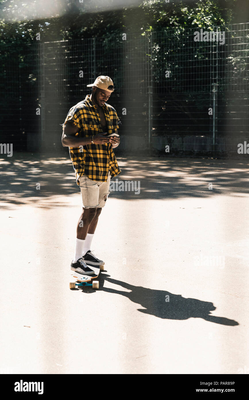 Cooler junger Mann in Skate Park, mit Smartphone Stockfoto