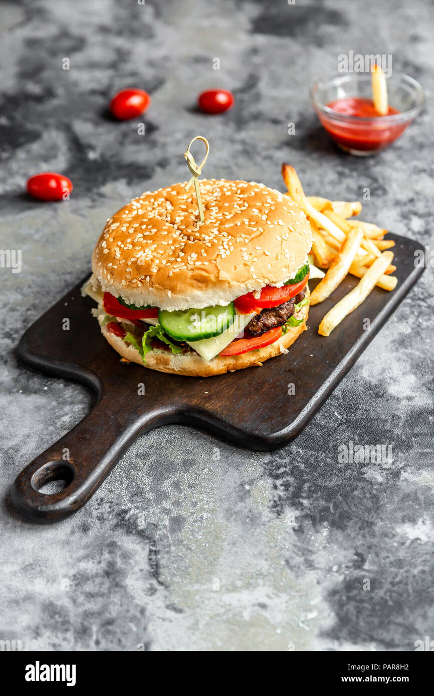Hausgemachte Hamburger mit Käse, Pommes frites, Ketchup und Tomatenmark ...