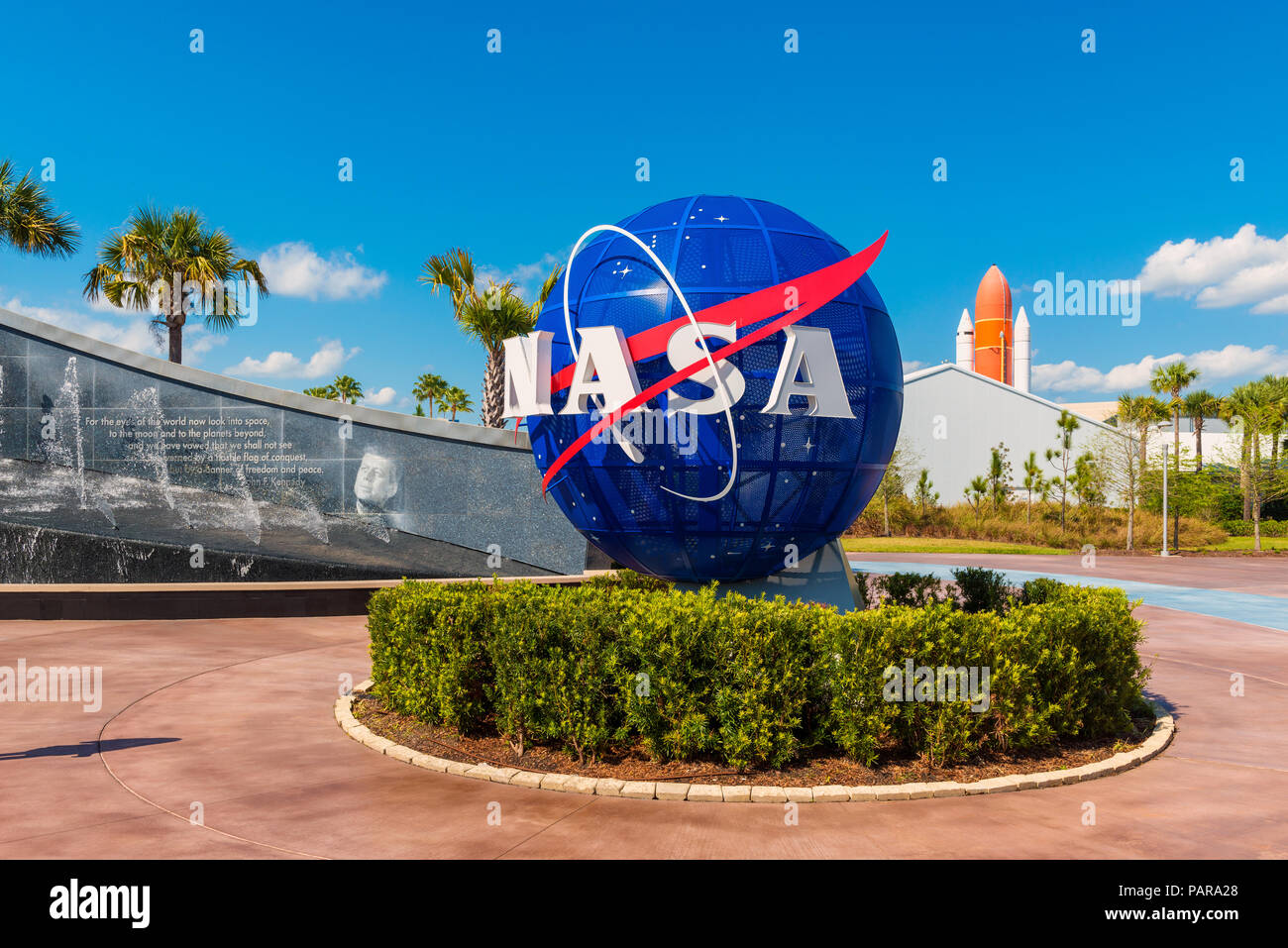 NASA-Logo auf Weltkugel im Kennedy Space Center Visitor Komplex in Cape Canaveral, Florida, USA. Auf der linken Seite ist ein Bild sichtbar von John F. Kennedy. Stockfoto