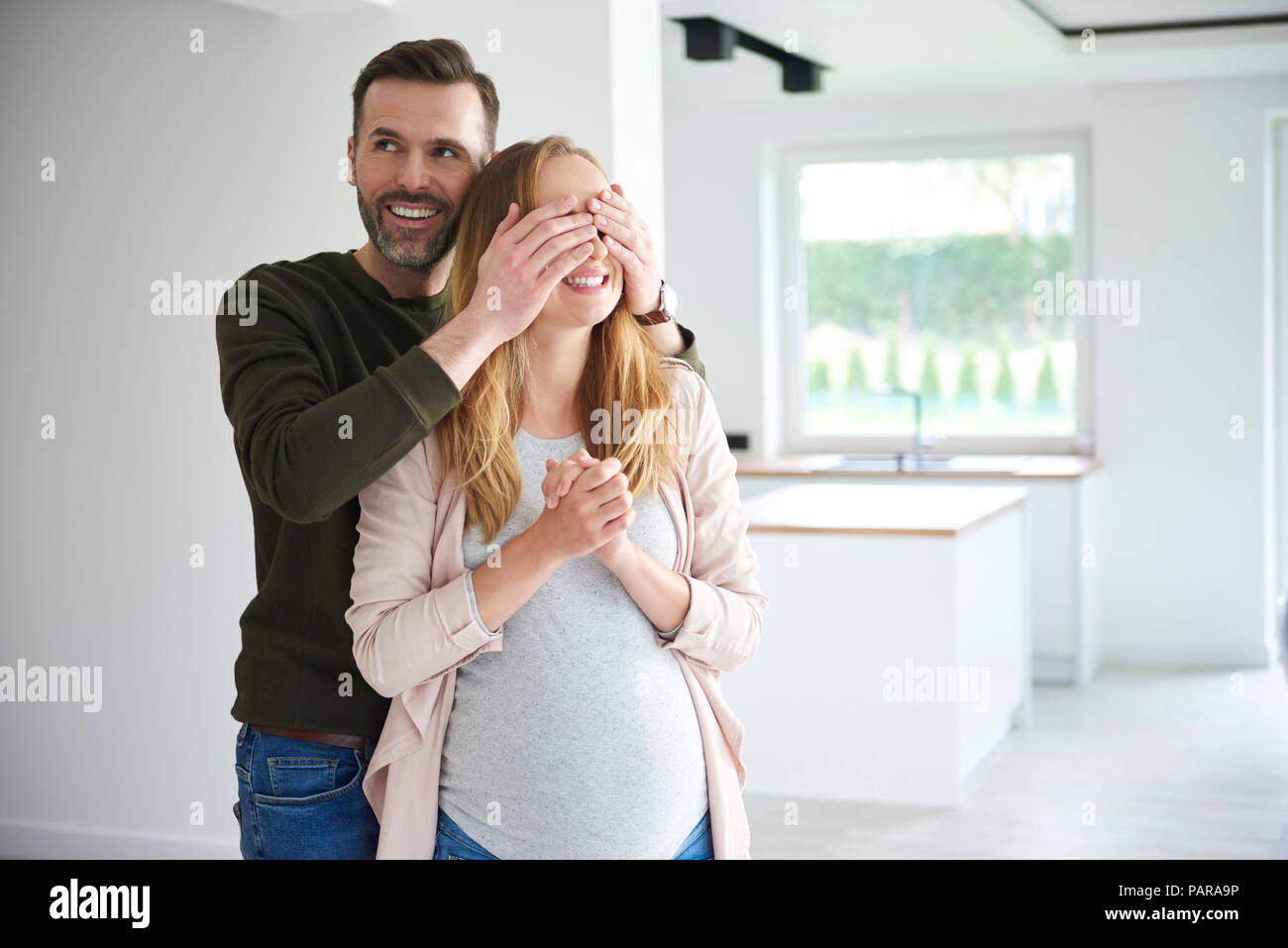Mann überraschend schwangere Frau in der leeren Wohnung Stockfoto