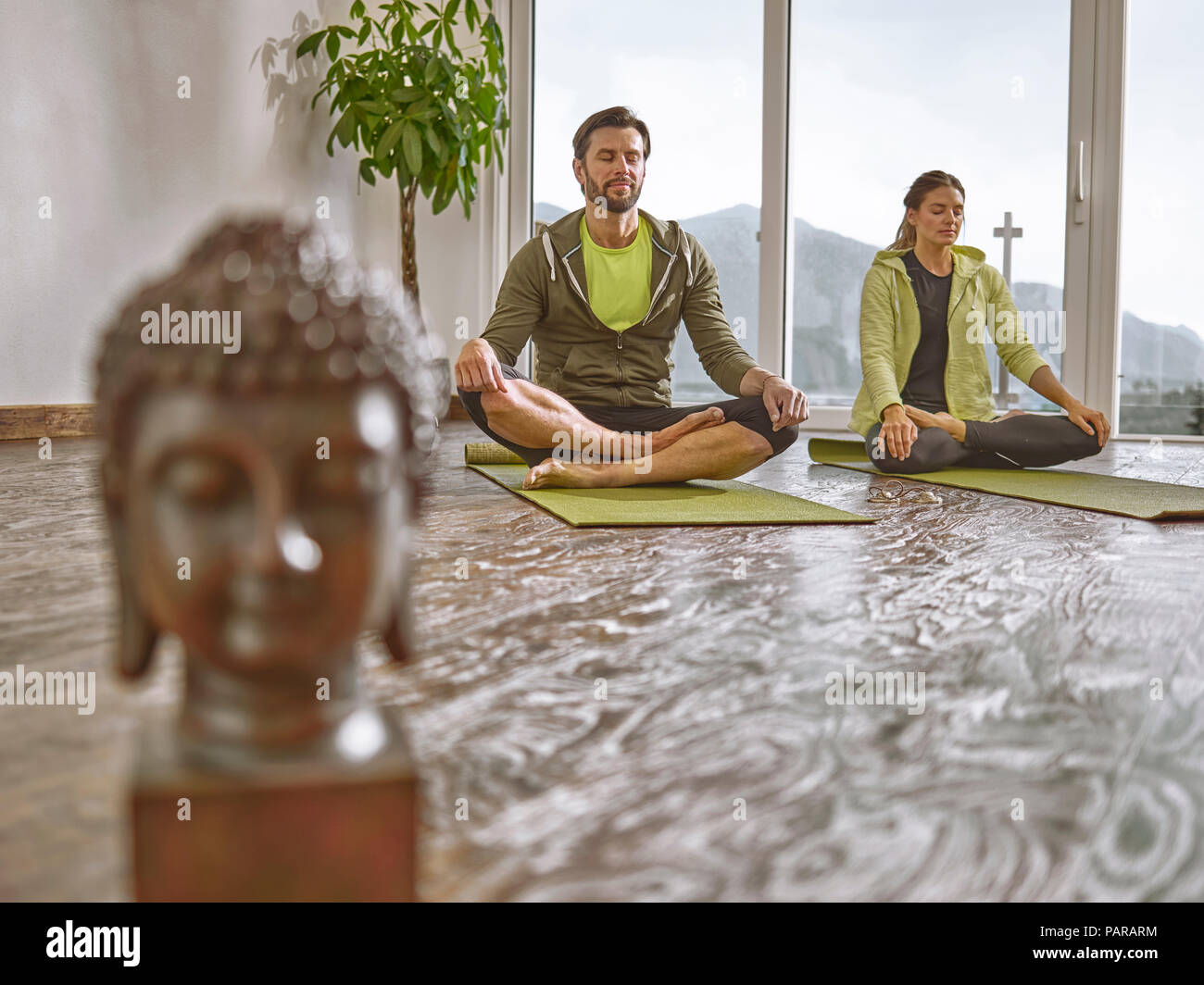 Paar Üben Yoga in einem Zimmer mit Panorama Fenster Stockfoto