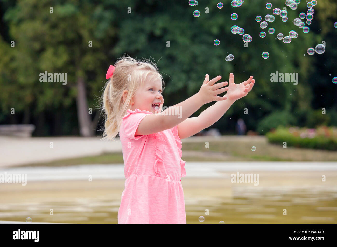Drei Jahre alten Mädchen spielen mit Seifenblasen Stockfoto