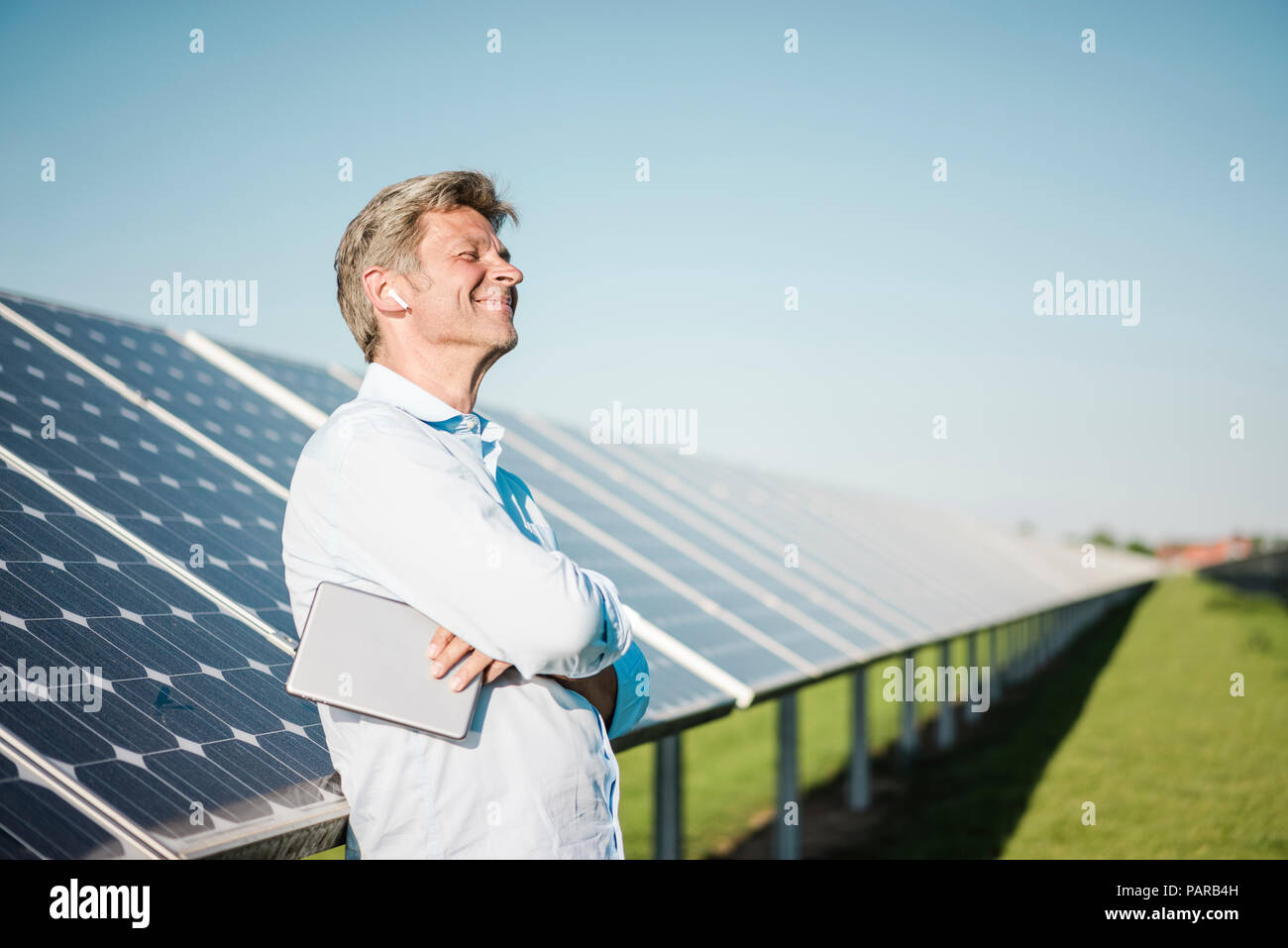 Geschäftsmann mit drahtlosen tablet Ohrhörer bei Solar Park Stockfoto