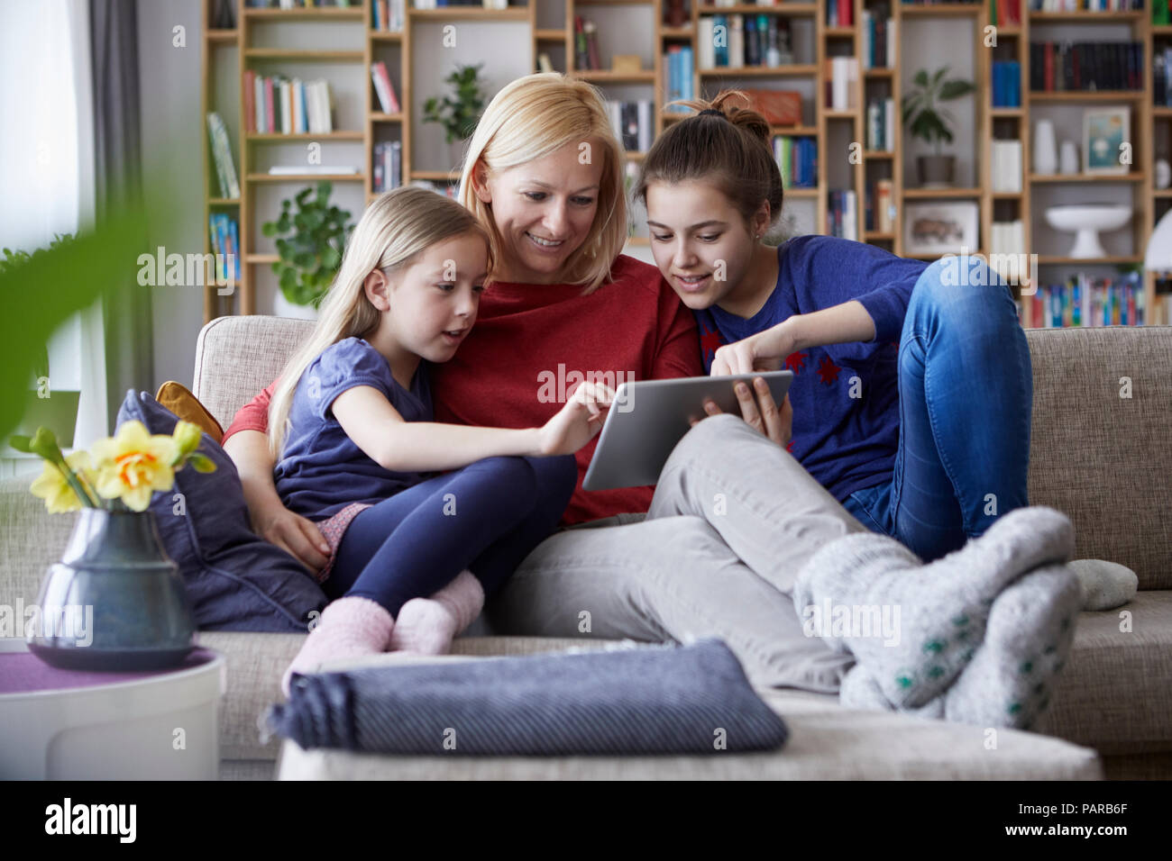 Mutter und ihre Töchter auf der Couch sitzen, Spaß mit digitalen Laptop Stockfoto