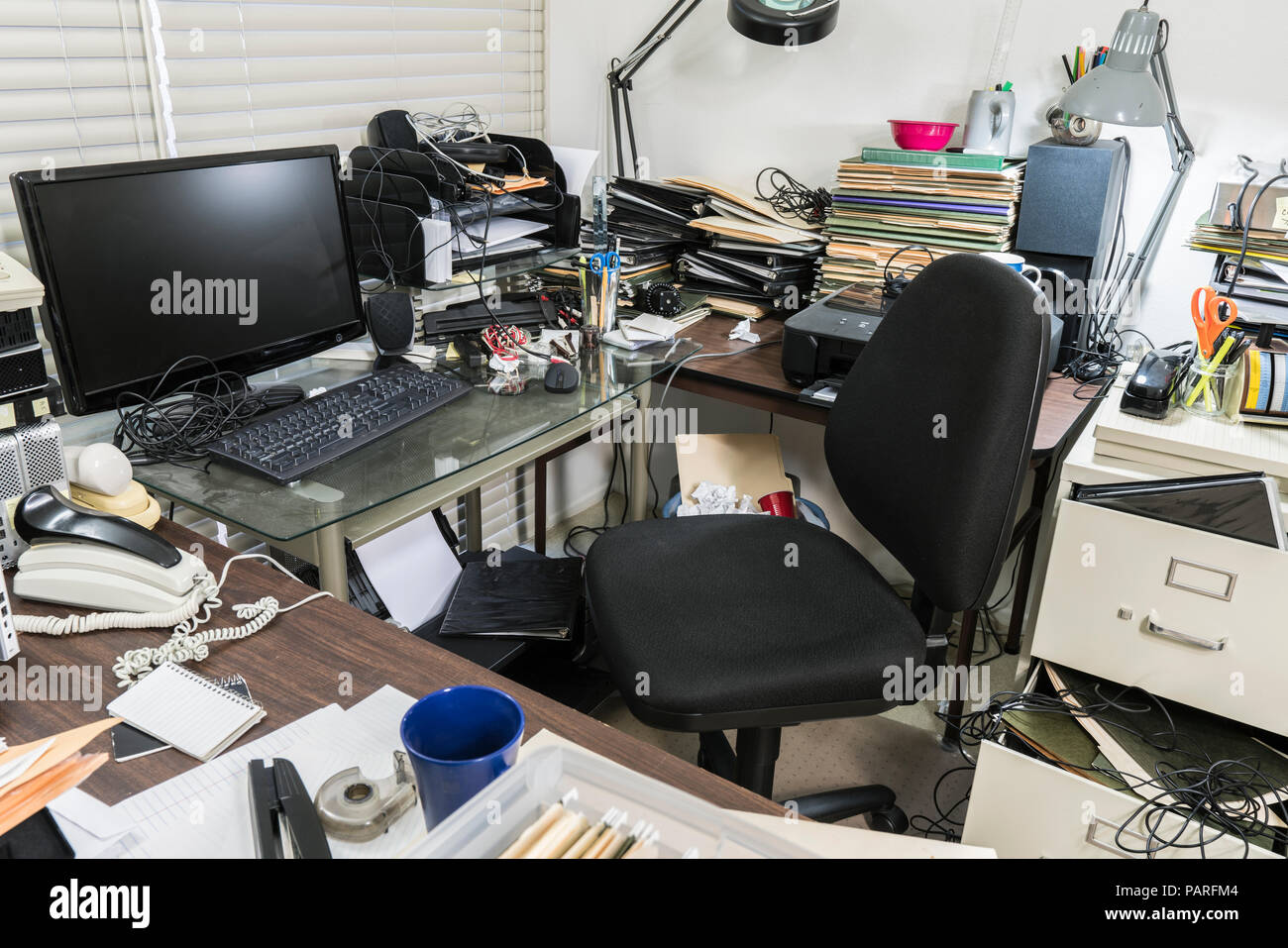 Unordentliches Büro Schreibtisch mit Stapeln von Dateien und ungeordnet durcheinander. Stockfoto