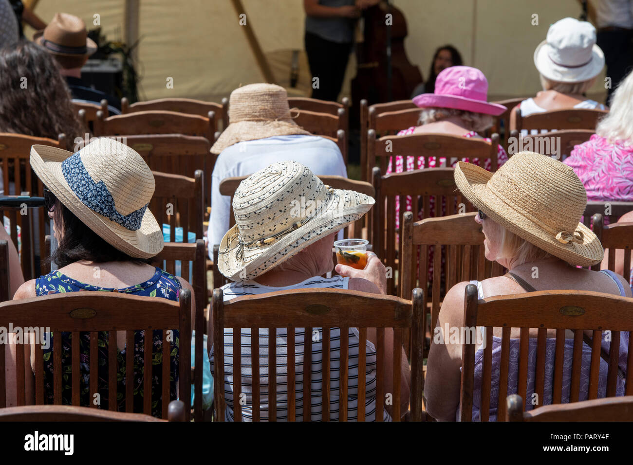 Frauen tragen im Sommer Hüte sitzen in Stühlen aus Holz an der RHS Hampton Court Flower Show. London, Großbritannien Stockfoto