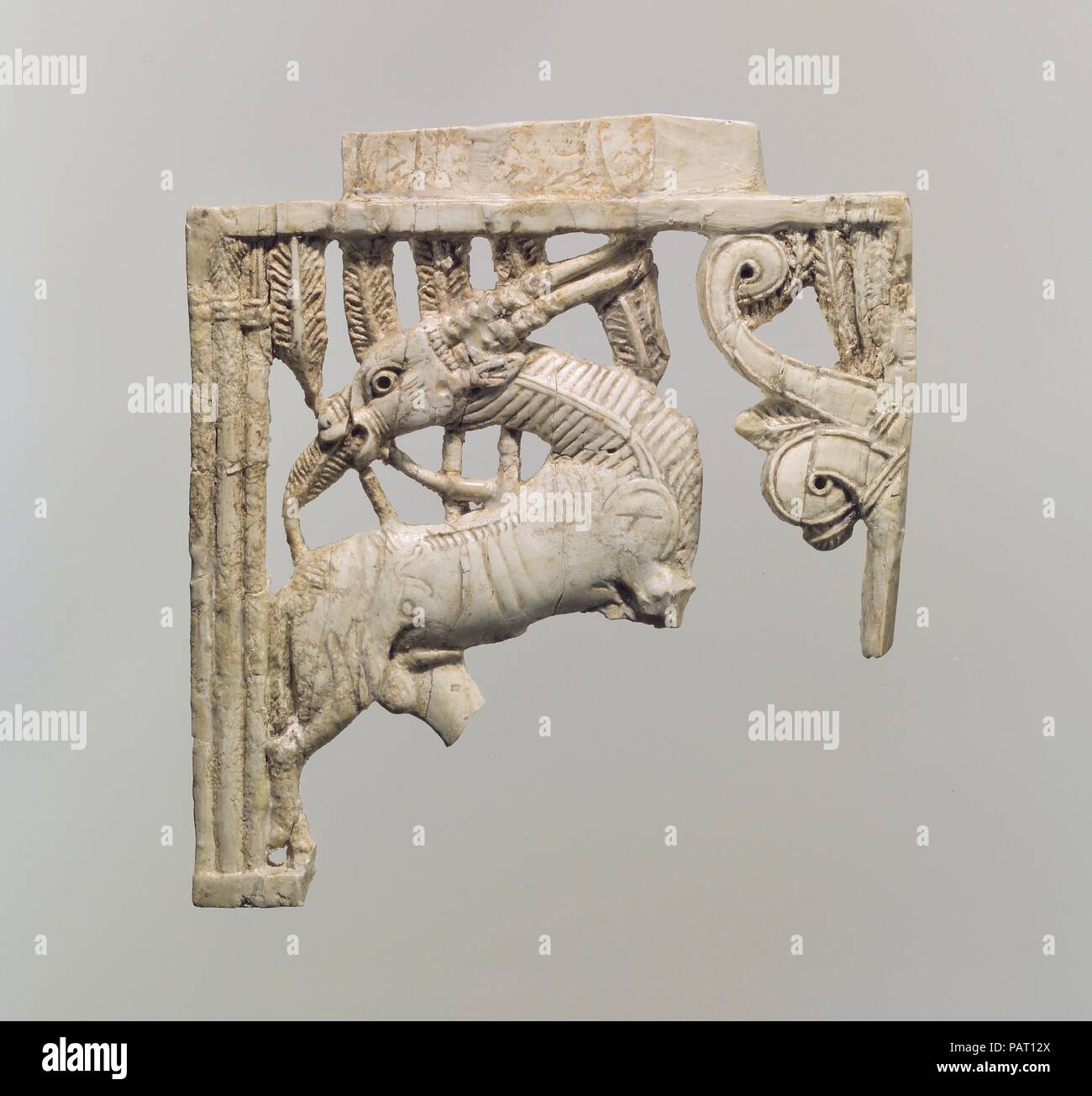 Openwork Möbel Plakette mit einer beweidung Oryx in einem Wald von Wedel. Kultur: Assur. Abmessungen: 5 x 4,69 x 0,43 Zoll. (12.7 x 11.91 x 1.09 cm). Datum: Ca. 9.-8. vorchristlichen Jahrhundert. Möbel mit Intarsien mit geschnitztem Elfenbein Plaketten war sehr von der assyrischen Könige geschätzt. Während der 9. bis 7. Jahrhundert v. Chr., riesige Mengen von Luxusgütern, oft verziert mit geschnitzten Elfenbein in lokalen, syrischen, und phönizischen Stile, in assyrischen Paläste angesammelt, viel von ihm als Beute oder Tribut. Dieses Objekt gehört zu einer Gruppe von Plaketten, Tiere und stilisierten Pflanzen. Sie wurden von Master Carver in einer Stockfoto