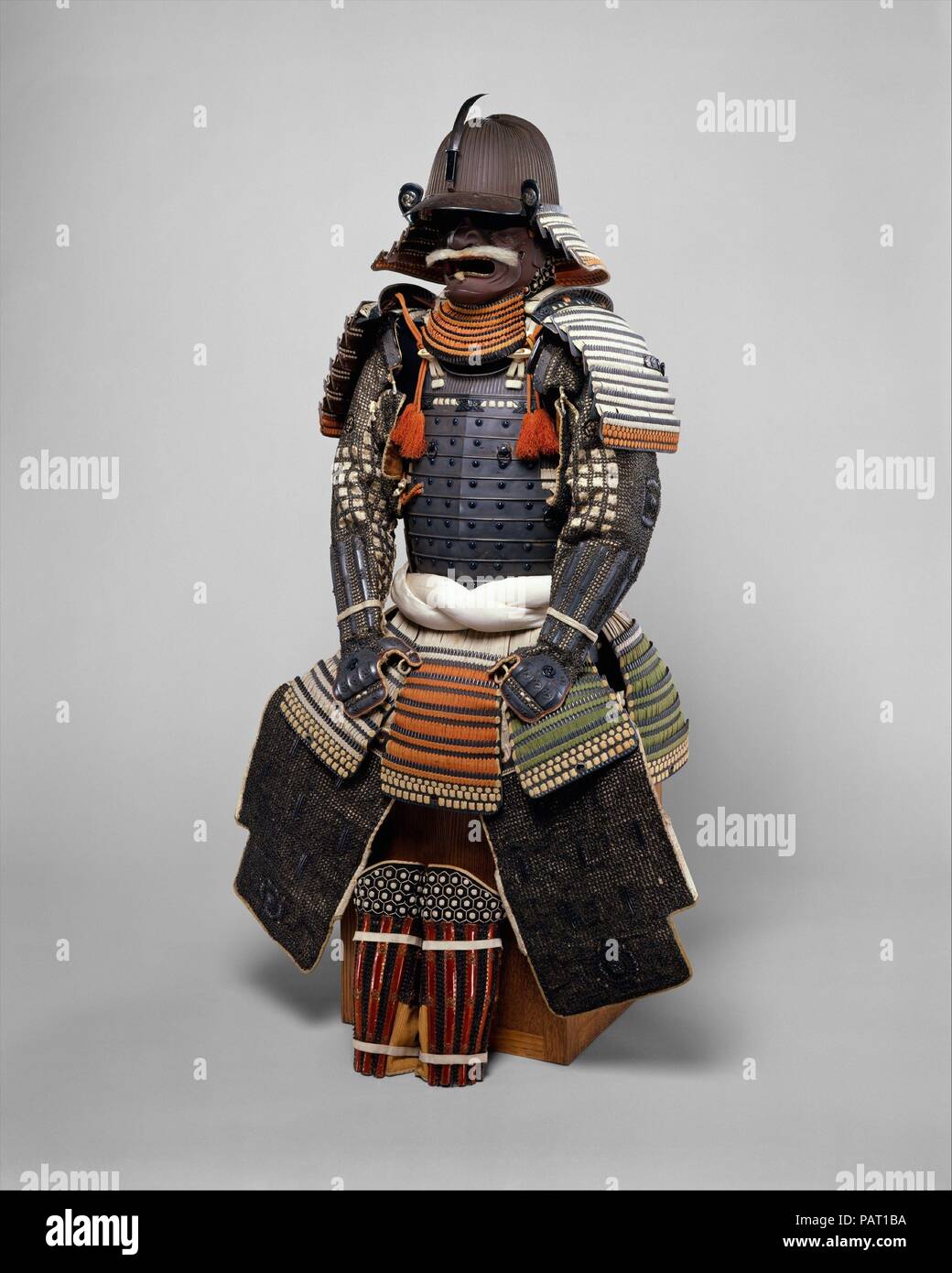 Rüstung (Gusoku). Armorer: Helm, unterzeichnet von Bamen Tomotsugu (Japanisch, Eichizan Provinz, Toyohara, Aktiv 18. Jahrhundert). Kultur: Japanisch, Toyohara, Eichizan Provinz. Abmessungen: Wie montiert, H. 58 5/8 in. (148,8 cm); W. 18 3/4 in. (47,6 cm). Datum: 18. Die Verarbeitung dieser Rüstung und seine Materialien sind von höchster Qualität. Es verfügt über einen <i> kusazuri</i> (Rock) mit einem extrem seltene Farbschema aus Seide Schnürung in Rot, gelb-grün, schwarz, und Weiß. Die <i>Mo</i> (heraldischen Abzeichen), in Form von drei wirbelnden Kommas (<i> mitsudomoe Mon</i>), ist die der Okabe Familie, Feu Stockfoto