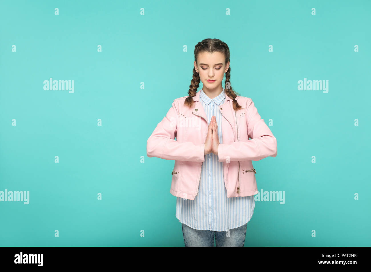 Meditation und yoga Porträt der schönen süße Mädchen stehend mit Make-up und Frisur in braunen Zopf gestreift Hellblau shirt rosa Jacke. Indoor, Stockfoto