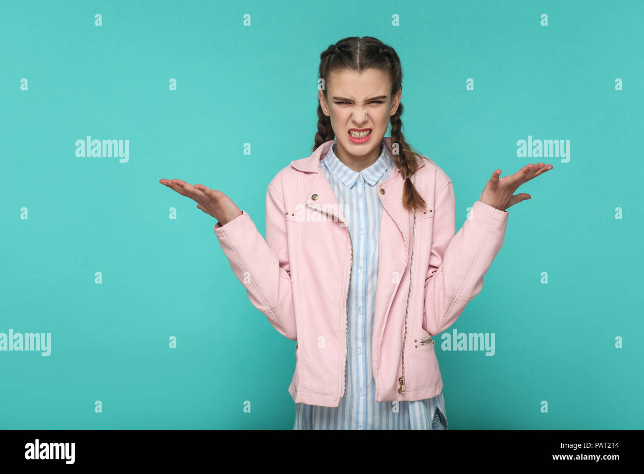 Was wollen Sie? Porträt der schönen süße Mädchen stehend mit Make-up und Frisur in braunen Zopf gestreift Hellblau shirt rosa Jacke. Indoor, st Stockfoto