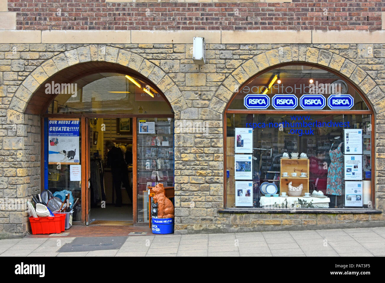 Außen zwei Bögen & stein Wand der RSPCA Charity Shop front Store Eingang & Fenster Anzeige der Spenden für Verkauf Haltwhistle Northumberland, England Großbritannien Stockfoto