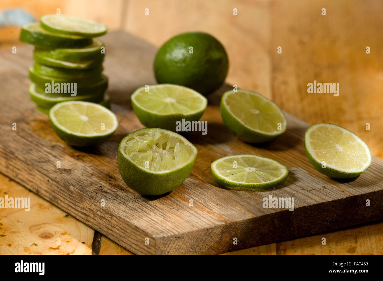 Ganze geschnitten und halbiert Limes auf Holz Schneidebrett Stockfoto
