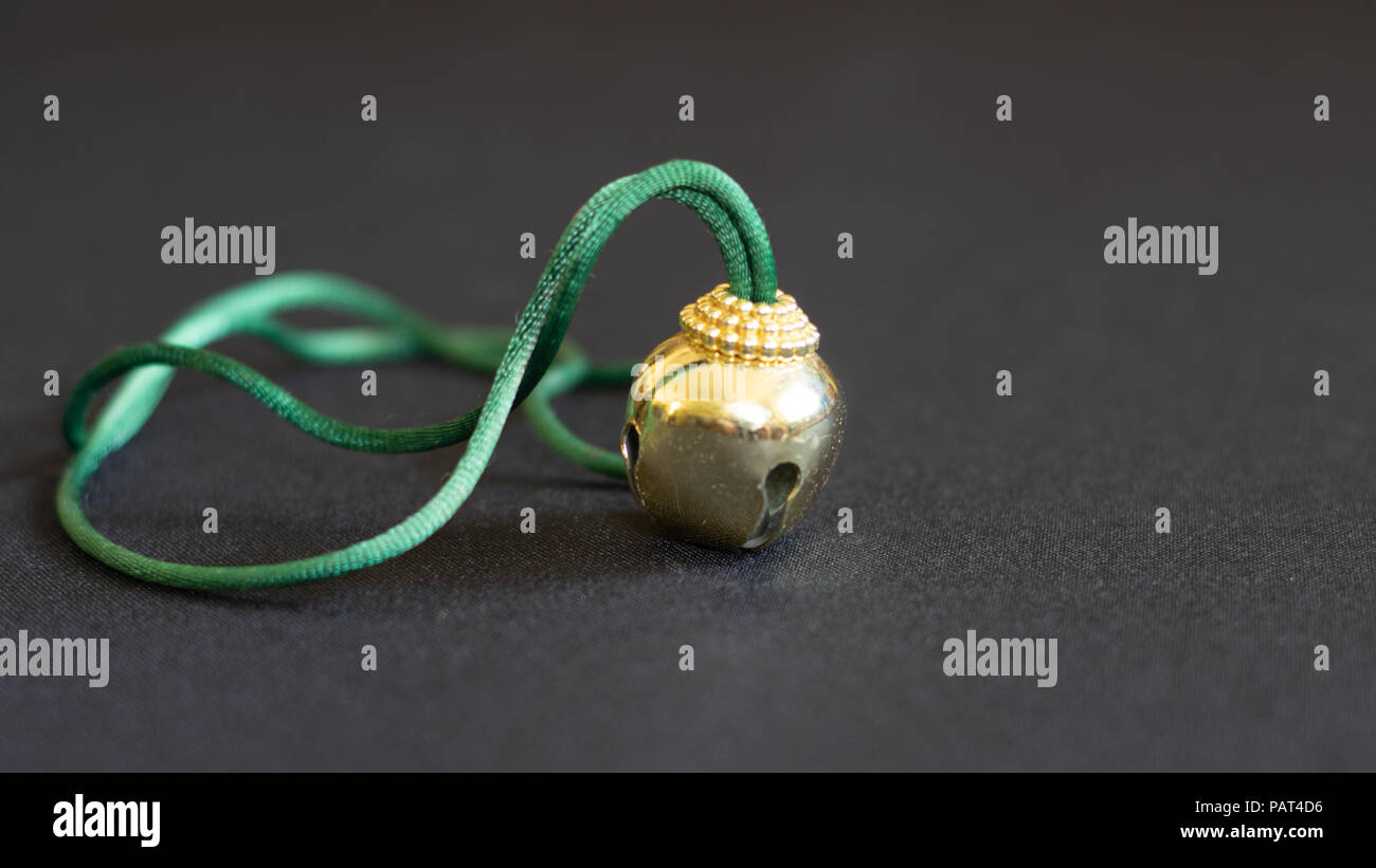 Urlaub Vintage Gold Weihnachten Jingle Bell Halskette mit grünem Kabel Stockfoto