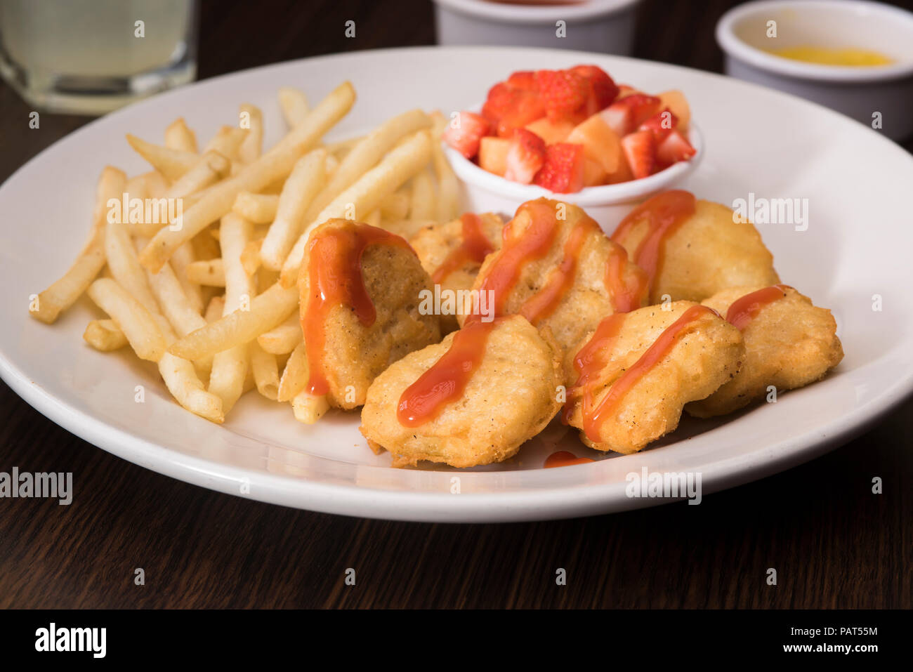 Nuggets und Pommes Frites mit einer Erdbeere Seite Stockfoto