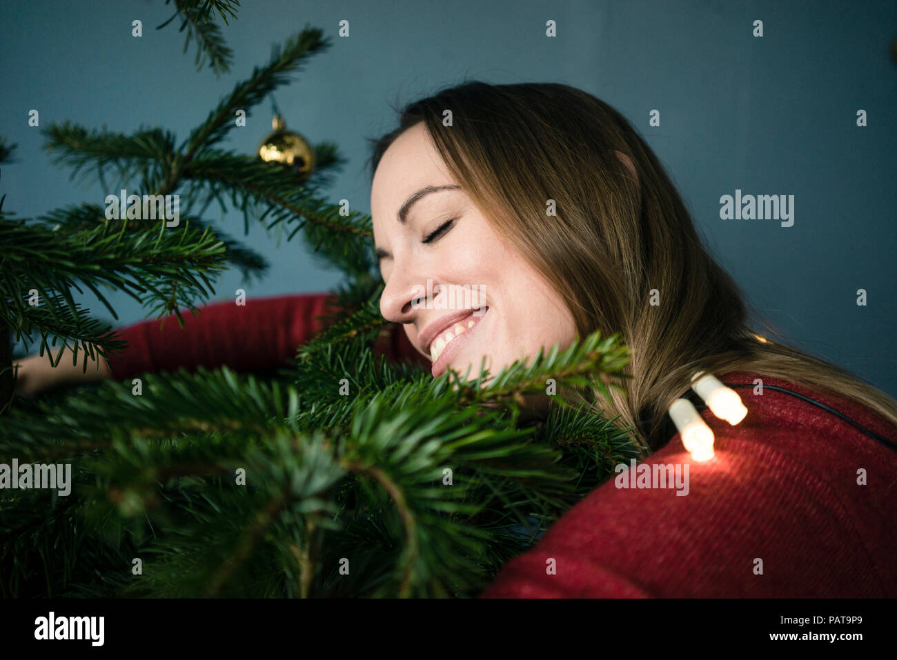Glückliche Frau umarmen Weihnachtsbaum Stockfoto