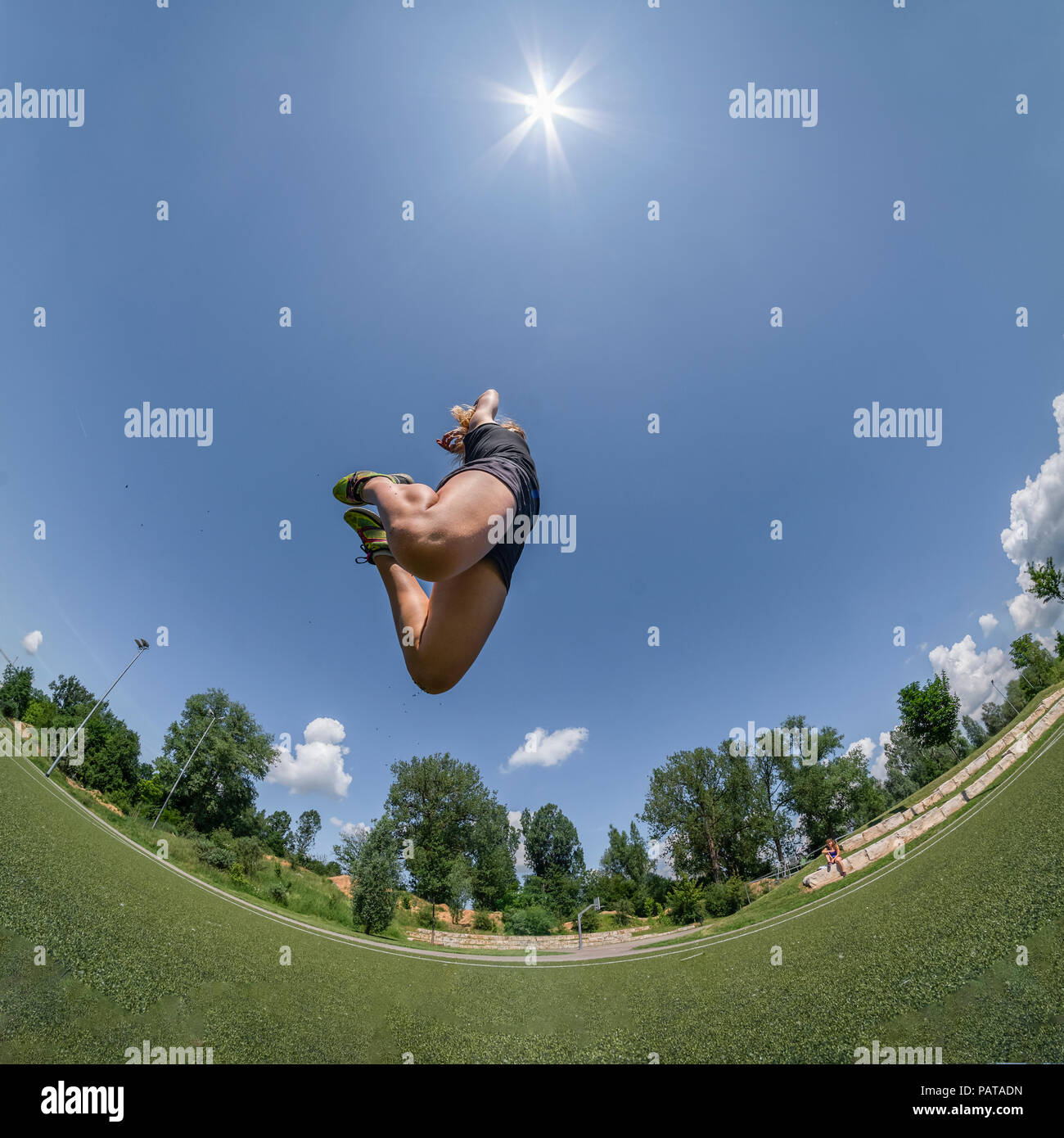 Sportliche Frau, springen in die Luft gegen die Sonne, Fisheye Stockfoto