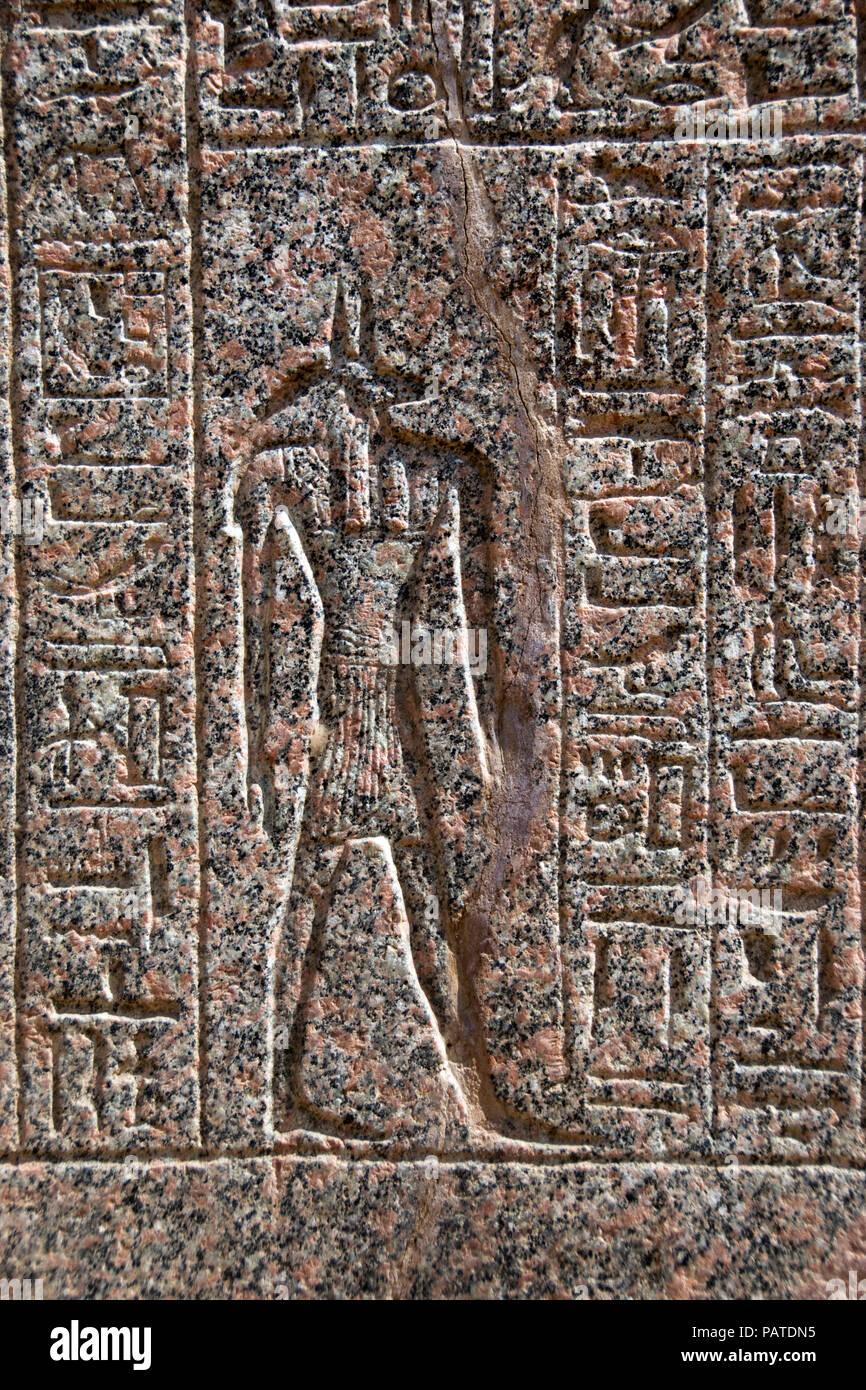 Der Schakal vorangegangen Ägyptischer Gott Anubis auf einem Sarkophag aus rotem Granit aus dem antiken Memphis geschnitzt, an modernen mit Rahina, Ägypten angezeigt. Stockfoto