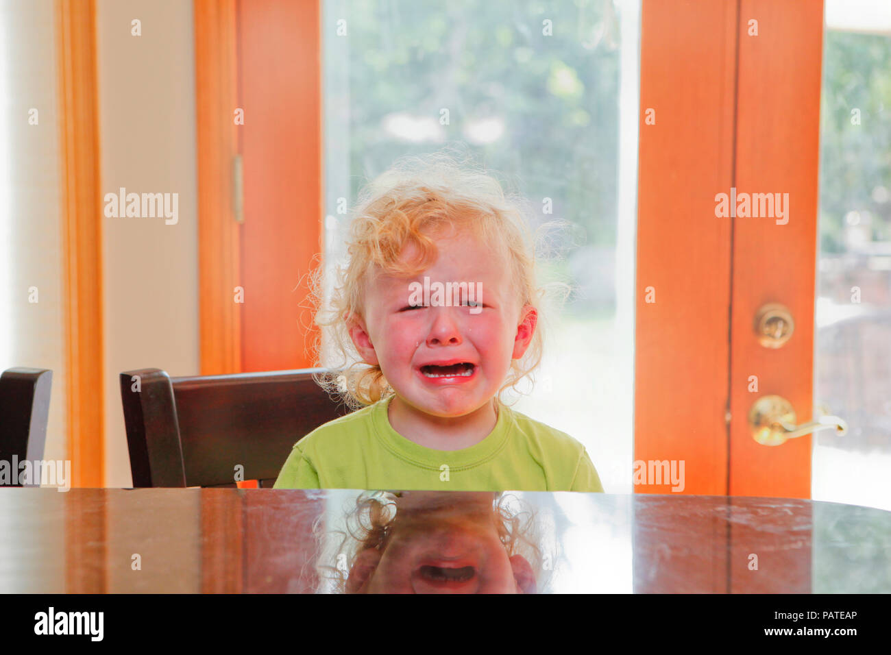 Weinende Kind an der Küchentheke mit Hintergrund Stockfoto