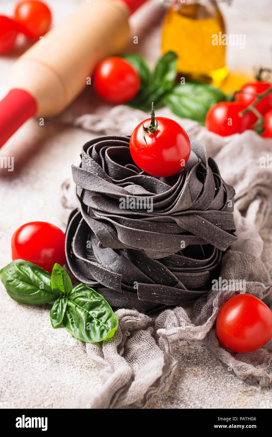 Schwarz Teigwaren mit Tomaten und Basilikum Stockfoto