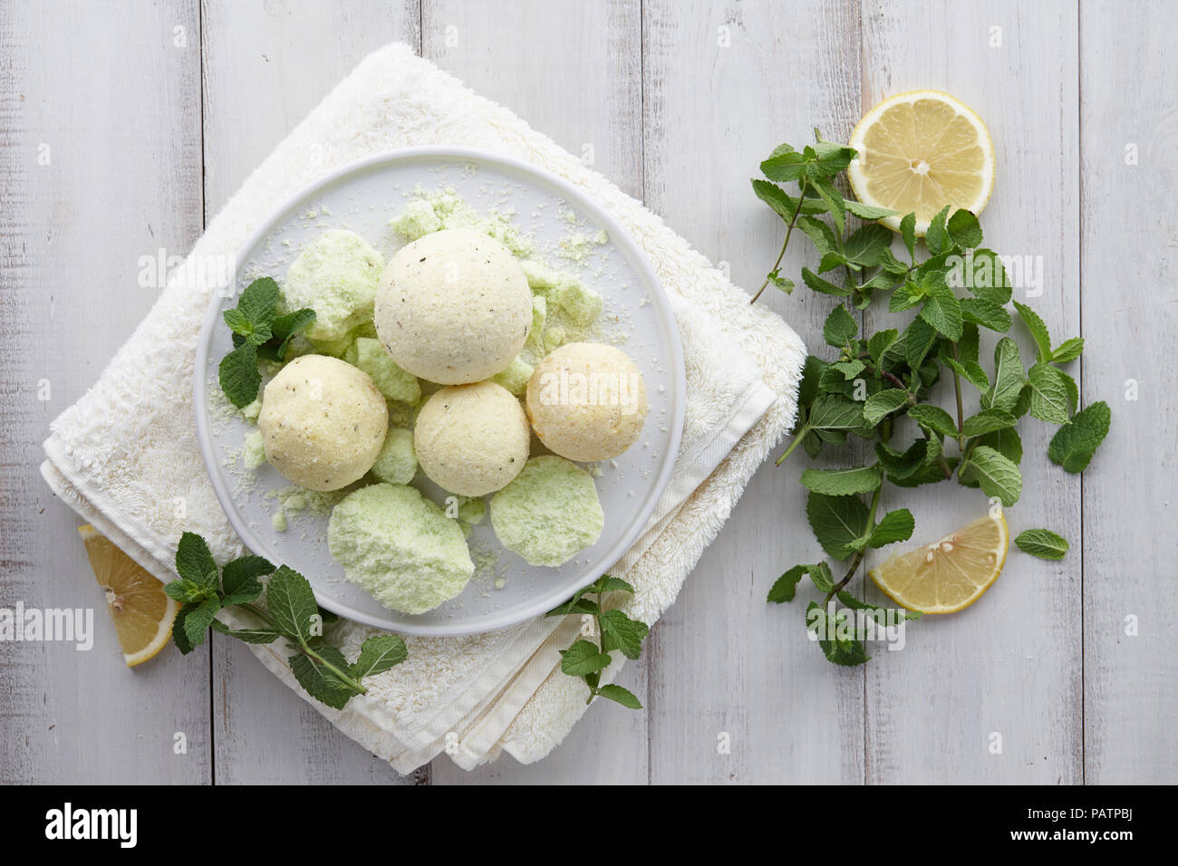 Handgefertigte Minze Bad Bomben und Handtuch auf weißen Planken Stockfoto