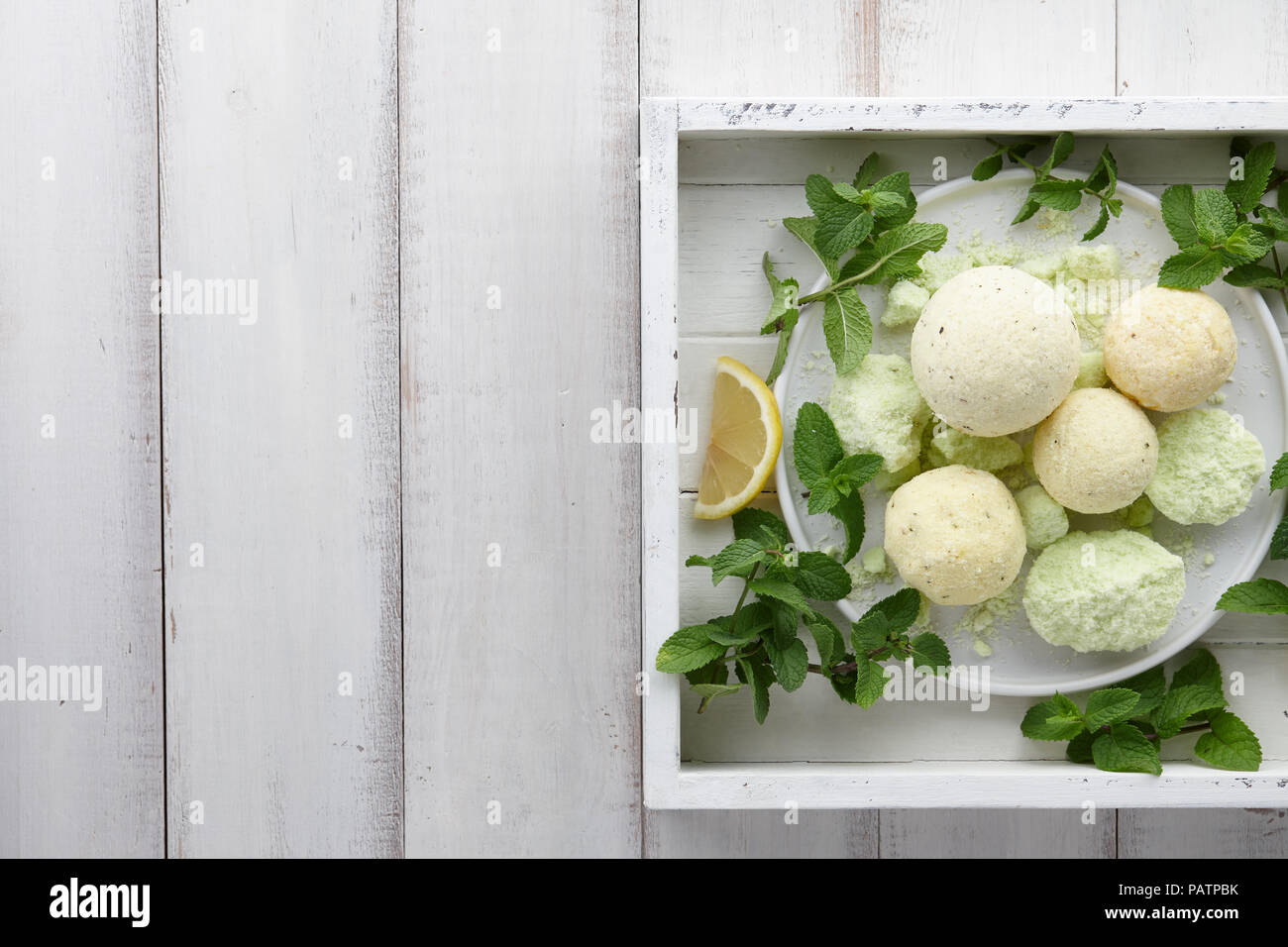 Handgefertigte Minze Bad Bomben mit frischen Kräutern in Weiß Fach Stockfoto