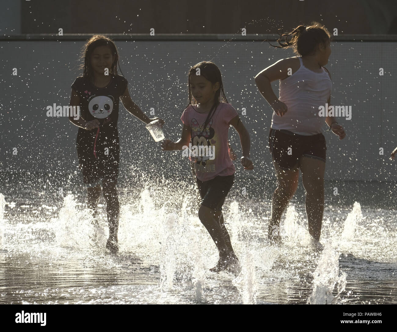 Los Angeles, Kalifornien, USA. 24. Juli, 2018. Kinder Abkühlung im Brunnen im Grand Park in der Innenstadt von Los Angeles Dienstag, 24. Juli 2018. Eine übermäßige Wärme Warnung geplant durch Donnerstag gebackene der Süden für einen zweiten Tag heute letzte, gesundheitliche Bedenken für Bewohner und fordert eine Aufforderung zur freiwilligen Stromeinsparung. National Weather Service Meteorologen sagten Dienstag und Mittwoch erwartet wurden die heißesten Tage des Heat Wave zu sein. Credit: Ringo Chiu/ZUMA Draht/Alamy leben Nachrichten Stockfoto