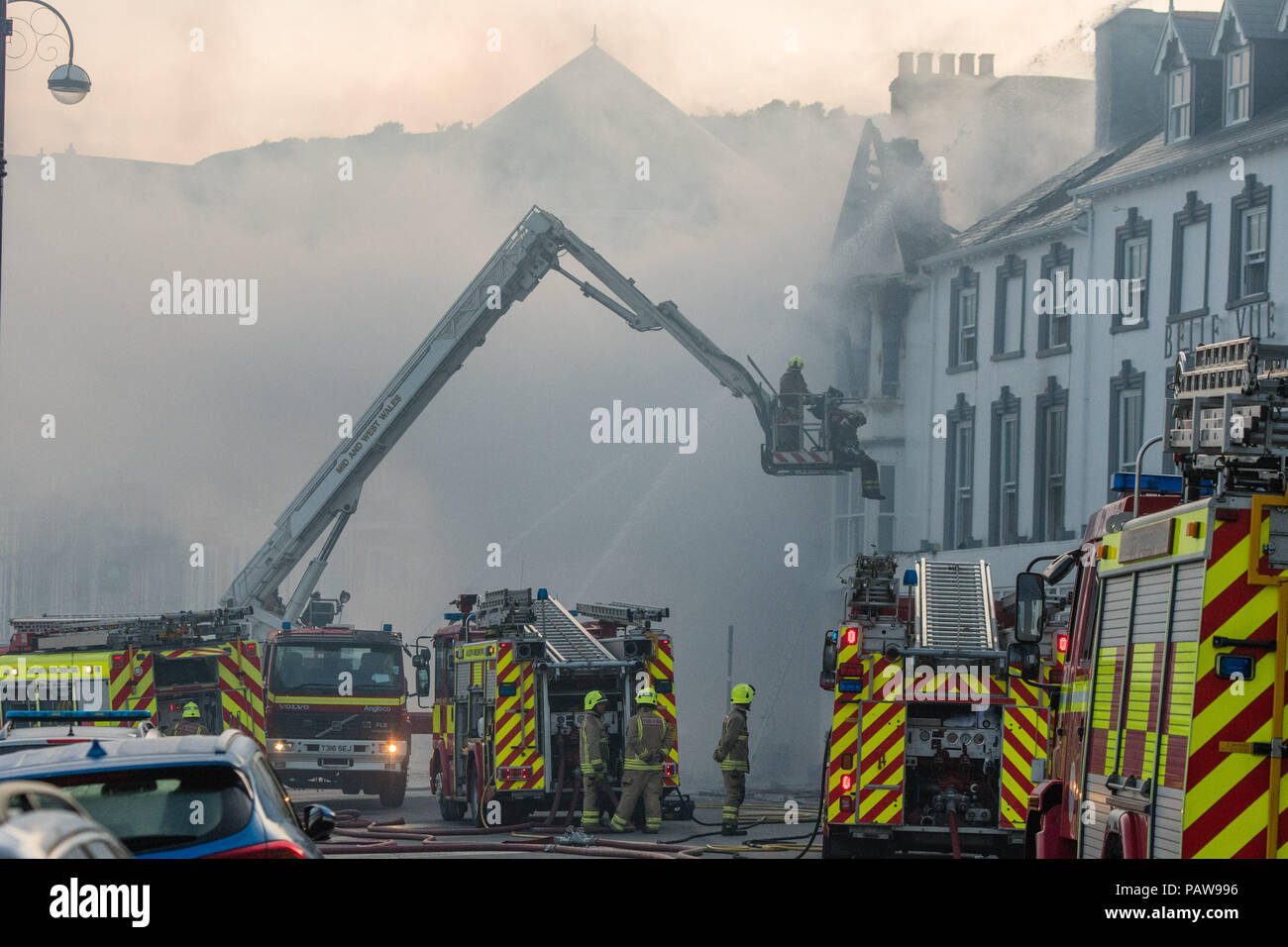 Aberystwyth Wales UK, Mittwoch, 25. Juli 2018 ein Großbrand wurde stark beschädigt auf zwei angrenzenden Hotels Aberystwyth Strandpromenade. Das Belle Vue Hotel und die Belgrave House Hotel Feuer fing um 2 Uhr heute Morgen, Feuerwehrfahrzeuge aus aller Mitte und West Wales haben in Anwesenheit während der Nacht. Es gibt keine Berichte über Opfer, und alle Gäste in andere Unterkünfte verlegt worden. Das Zentrum der Stadt ist aus Sicherheitsgründen Photo Credit: Keith Morris/Alamy Leben Nachrichten weitraeumig abgesperrt, Stockfoto