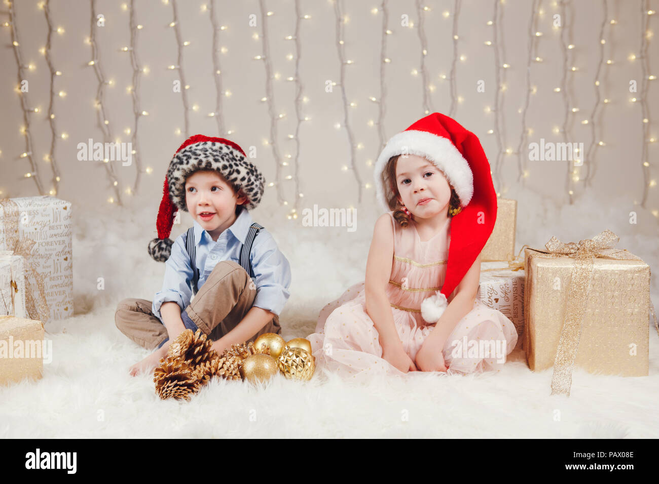 Portrait von weissen Kaukasischen Kinder Freunde Geschwister feiern  Weihnachten oder Neujahr. Little cute adorable Mädchen und Jungen tragen  Santa Claus Hüte si Stockfotografie - Alamy