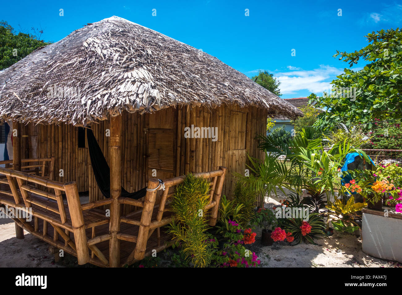Ein rustikales philippinischen Insel Bungalow mit Hängematte und Blumen im Garten - Malapascua, Cebu - Philippinen Stockfoto