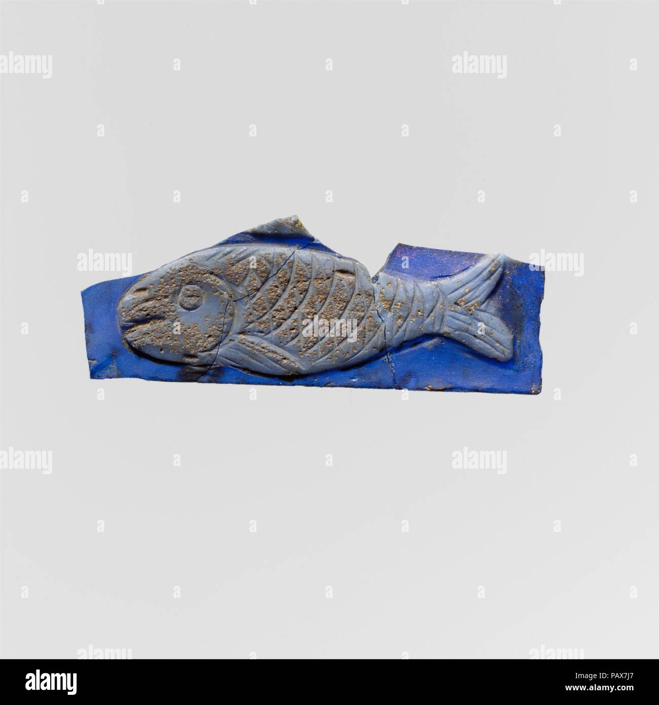 Glas cameo Fragment. Kultur: Roman. Abmessungen: 13/16 x 2 1/8 x 1/8 in. (2 × 5,4 × 0,3 cm). Datum: 1. Halbjahr 1. Jh. N.CHR.. Transluzente Kobaltblau und opak Hellblau. Flache Plakette oder Inlay, dekoriert mit einer oberen Schicht in Relief geschnitzt; glatte, flache zurück. Auf kobalt blau Masse, ein Fisch im Profil nach links weist, mit Flossen, Schuppen, Kiemen, Auge, Mund geschnitzt als seichte Einschnitte in der Oberfläche des oberen opak blau Layer; über Fisch, unteren Rand eines zweiten Relief, vielleicht einen anderen Fisch. Unten gerade Kante, unregelmäßige Pausen an den Seiten und oben; in zwei Fragmente zerlegt und repariert; Stockfoto