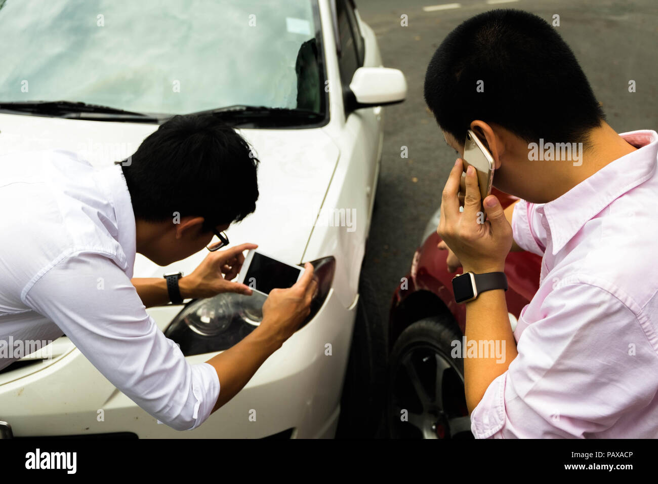 Ein Mann Anruf Kfz-Versicherung für Halp mit den Parteien aus dem Autounfall und ein Foto als Beweismittel zu verwenden. Anspruch auf Versicherungsleistungen Konzept. Stockfoto