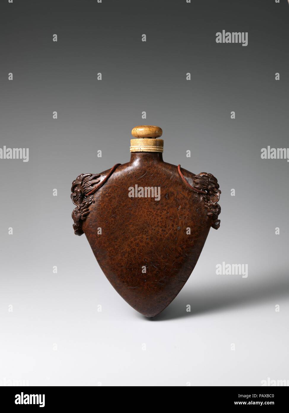 Schießpulver Kolben. Kultur: Chinesen. Abmessungen: H. 8 1/2 in. (21,6 cm); W. 6 3/4 in. (17,1 cm); D.1 1/2 in. (3,8 cm); Wt. 11.6 oz. (328.9 g). Datum: vermutlich aus dem 18. Jahrhundert. Die meisten Qing Schießpulver Flaschen sind recht einfach und utilitaristischen Behälter aus Holz, Metall, oder Horn. Dieses Beispiel ist sehr ungewöhnlich für seine kunstvoll geschnitzten Drachenköpfen und schön dargestellt, Wurzelholz, die oft in China verwendet wurde, feine Möbel zu machen. Museum: Metropolitan Museum of Art, New York, USA. Stockfoto