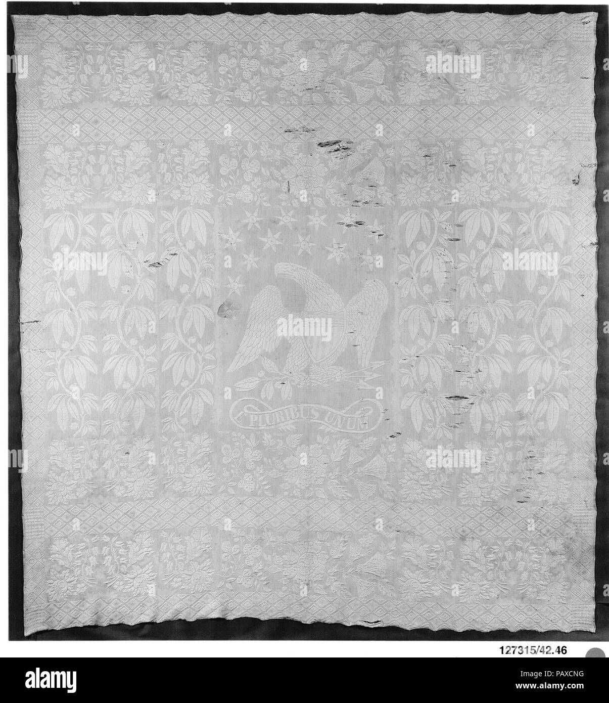 Steppdecke, Marsailles Typ. Kultur: Amerikanische oder Britische. Abmessungen: 104 1/4 in. x 97 in. (264.8 x 246.4 cm). Datum: Ca. 1876. Dieser Webstuhl gewebt Bed Cover hat Verwerfungen sowohl rote und weiße Baumwolle und einem Schuss aus weißer Baumwolle. Es war zu imitieren, handgewebte Quilten. Die zentrale Design ist ein Adler mit ausgebreiteten Flügeln über die Worte E PLURIBLIS UNUM stehen. Dreizehn Sterne sind sichtbar, über dem Kopf des Adlers. Die restlichen Boden ist mit Blumen und Laub Grenzen fallen. Museum: Metropolitan Museum of Art, New York, USA. Stockfoto