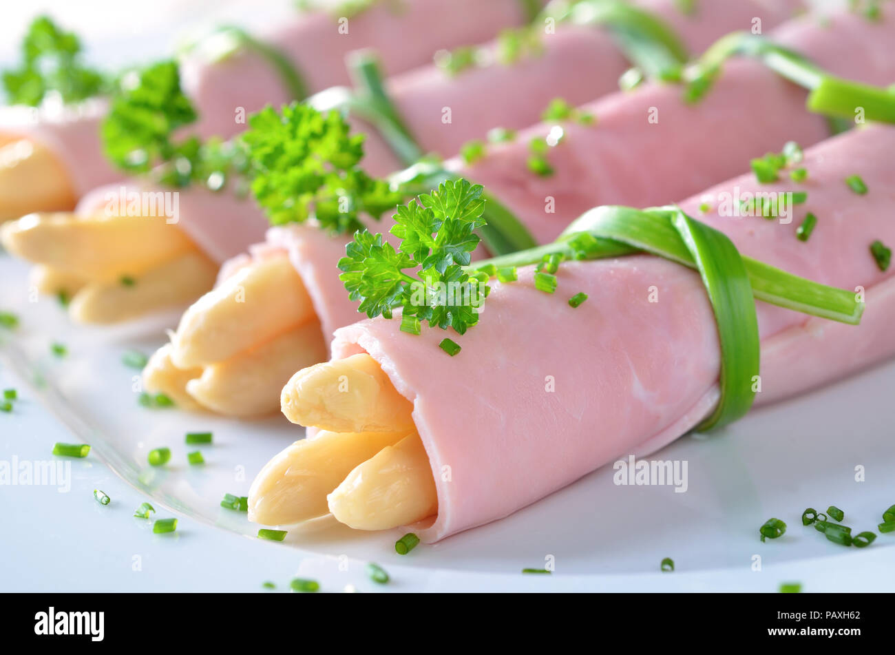 Rollte mit gekochtem Schinken gefüllt mit Spargel Stockfoto