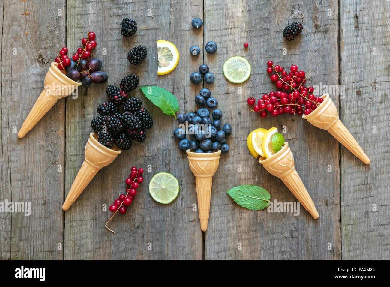 Beeren in Eiscreme Kegel (Heidelbeeren, rote Johannisbeere, Zitrone, Black, Traube, Minze). Gesund Sommer essen Konzept. Stockfoto