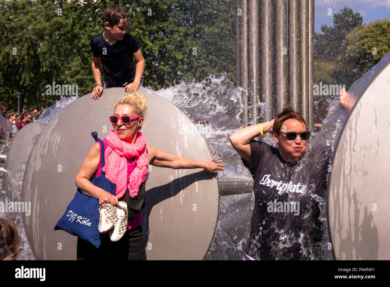 Die Menschen genießen die Brunnen von Wolfgang Goeddertz auf dem Ebertplatz, Köln, Deutschland. Menschen erfrischen sich am Brunnen von Wolfgang Goeddertz au Stockfoto