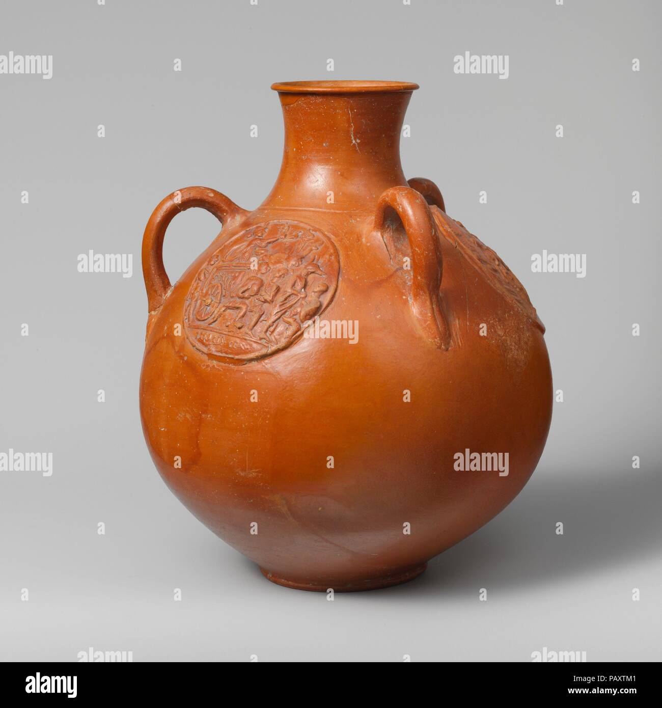 Drei- Kanne mit relief Medaillons. Kultur: Roman. Abmessungen: H. 8 9/16-in. (21,7 cm); Durchmesser 7 1/4 in. (18,5 cm). Datum: Ende 2./Anfang 3.Jh. N.CHR.. Dieses außergewöhnliche 3-Bearbeitet Krug ist mit angespritztem appliqué Festplatten eingerichtet. Zwei sind von der gleichen Form und der griechischen mythologischen Figuren Atalanta und Hippomenes darstellen. Der dritte Appliqué zeigt eine religiöse Prozession mit dem Cult Statue der ägyptischen Göttin Isis in einem Warenkorb vorgeführt wird. Die Kanne ist gefunden worden zu sein, bei Arausio (Orange, Südfrankreich), aber es war wahrscheinlich in einem Workshop in Lyon und Vienne i Stockfoto