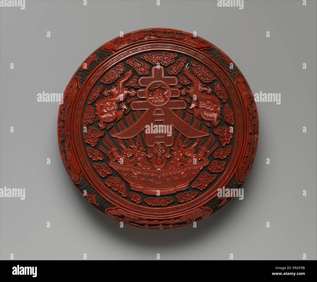 Kostbare Feder Langlebigkeit. Kultur: China. Abmessungen: Durchm. 13 1/4 in. (33,7 cm). Datum: 1736-1795. Die qianlong Kaiser beauftragt mindestens 18 Versionen von dieser Box. Insbesondere bewertet er die Konstruktion auf der Oberseite: eine große Darstellung der Zeichen für Feder (Chun, eine Anspielung auf lange Lebensdauer), und ein kleines Bild von shoulao, der Gott der Langlebigkeit. Der Charakter und die Überquellenden Schüssel Darunter sind vor dem Hintergrund einer strahlenden Regenbogen eingestellt. Die Schale der Schätze Motiv tauchte zuerst in geschnitzten Lack im sechzehnten Jahrhundert; es war in diesem komplizierter Progra integriert Stockfoto