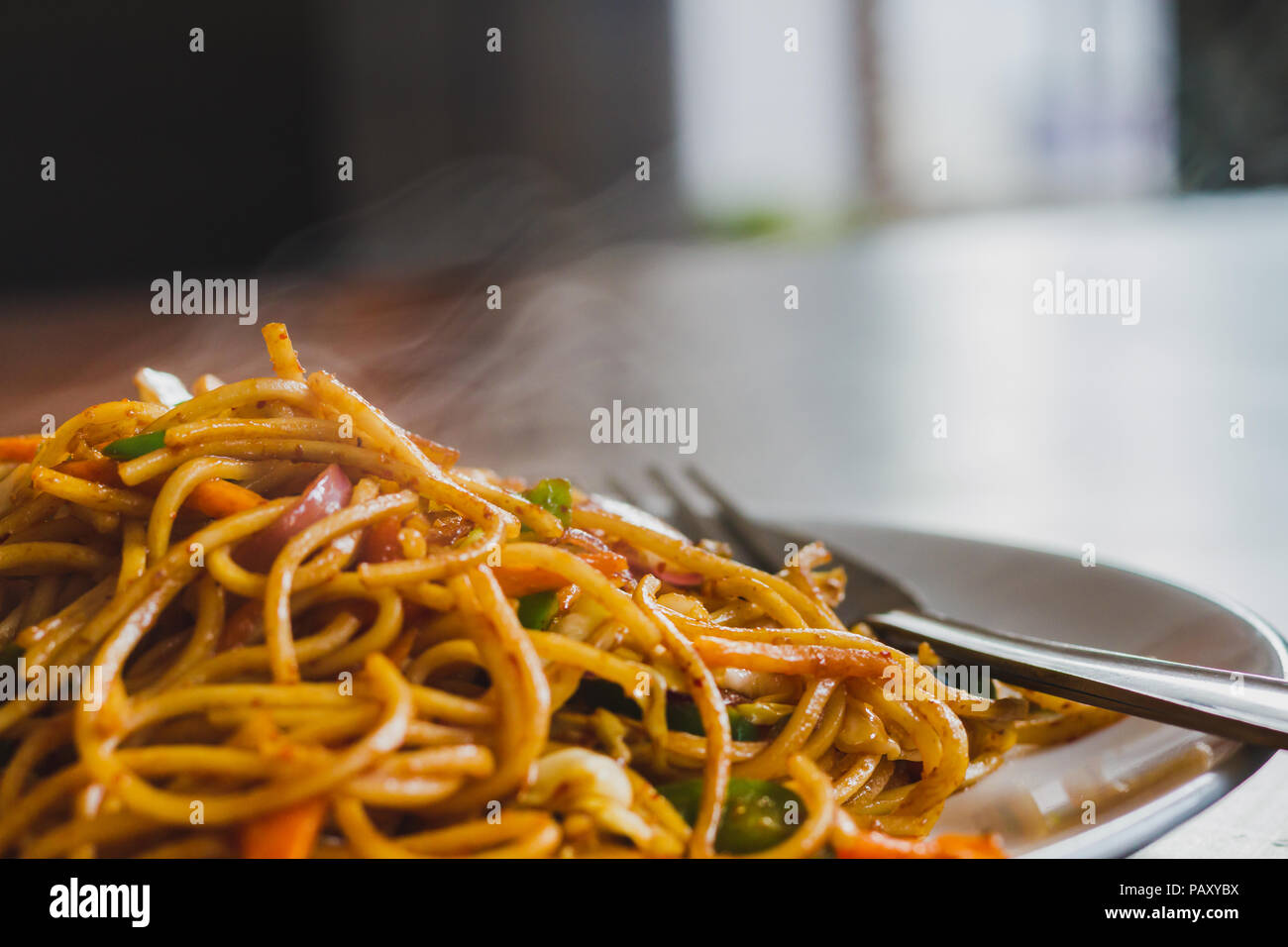 Chinesische Nudeln, Chowmein auf einem Teller mit Löffel und Gabel, heiß und frisch Chow Mein im nepalesischen Stil Stockfoto