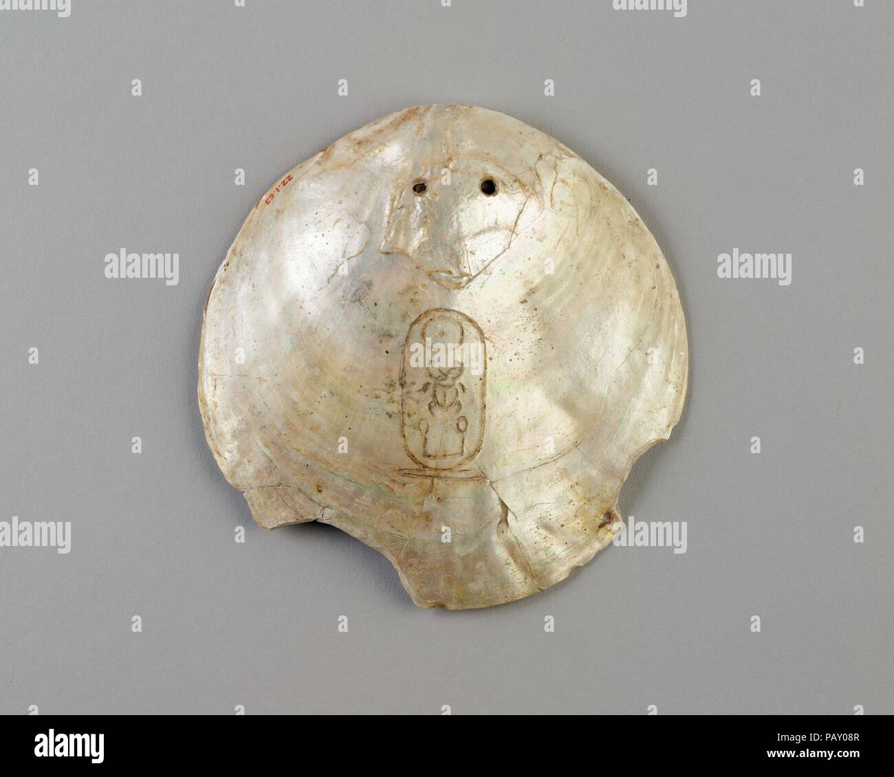 Shell bezeichnet mit der Kartusche des Senwosret I. Abmessungen: L 12,5 × W. 12 cm (4 15/16 x 4 3/4 in.). Dynastie: Dynasty 12. Herrschaft: Herrschaft des Senwosret I. oder später. Datum: Ca. 1961-1917 v. Chr. oder später. Poliert bis in die innere Schicht von Perlmutt (Perlmutt), diese Irisierenden Oyster Shell wurde mit zwei Löchern durchbohrt, so dass es könnte aufgereiht und hing um den Hals. Die königlichen Namen Senwosret hat in die Oberfläche eingeschnitten worden. Es ist eine von etwa fünfzig solcher bekannten Shells, die meisten eingeschrieben, wie in diesem Beispiel, mit dem Nomen (Geburtsname) Senwosret, oder mit dem Namen prenomen (Thron) Kheperkare. Stockfoto