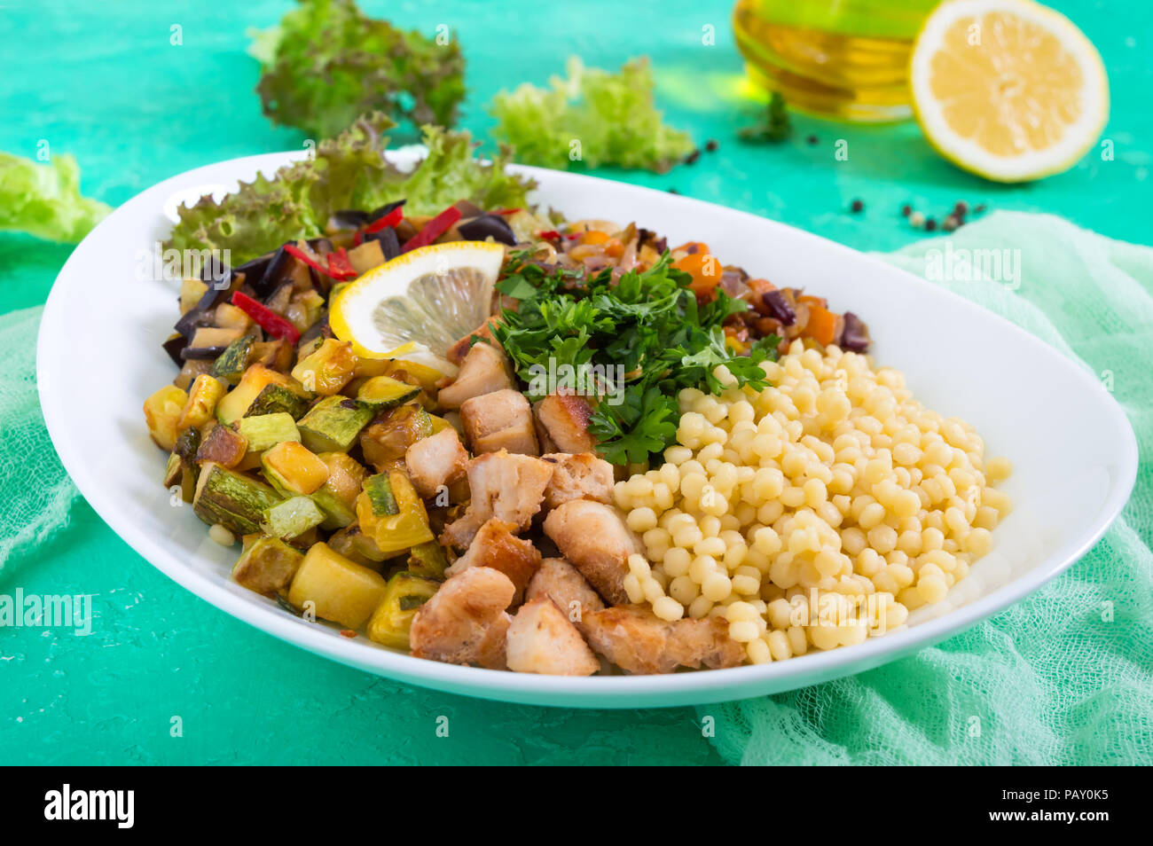 Köstliche orientalische Salat tabbouleh. Couscous mit gebratenem Gemüse und Huhn auf einem weißen Teller. Traditionelle libanesische Vorspeisen. Stockfoto