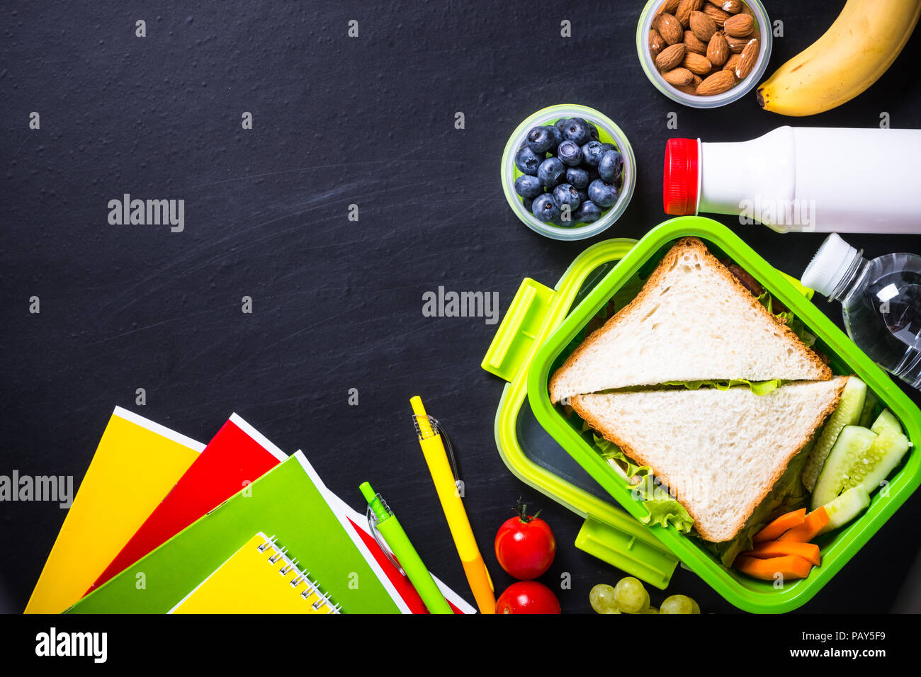 Zurück zum Konzept der Schule. Lunch Box mit Schreibwaren auf Schwarz. Stockfoto