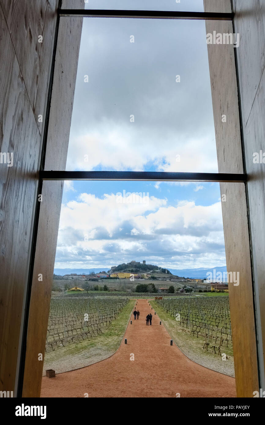 Blick auf die Stadt Laguardia in Spanien von einer hölzernen Fenster in der Weinverkostung Zimmer mit Menschen, die durch die rote Piste und Weinberge an. Stockfoto