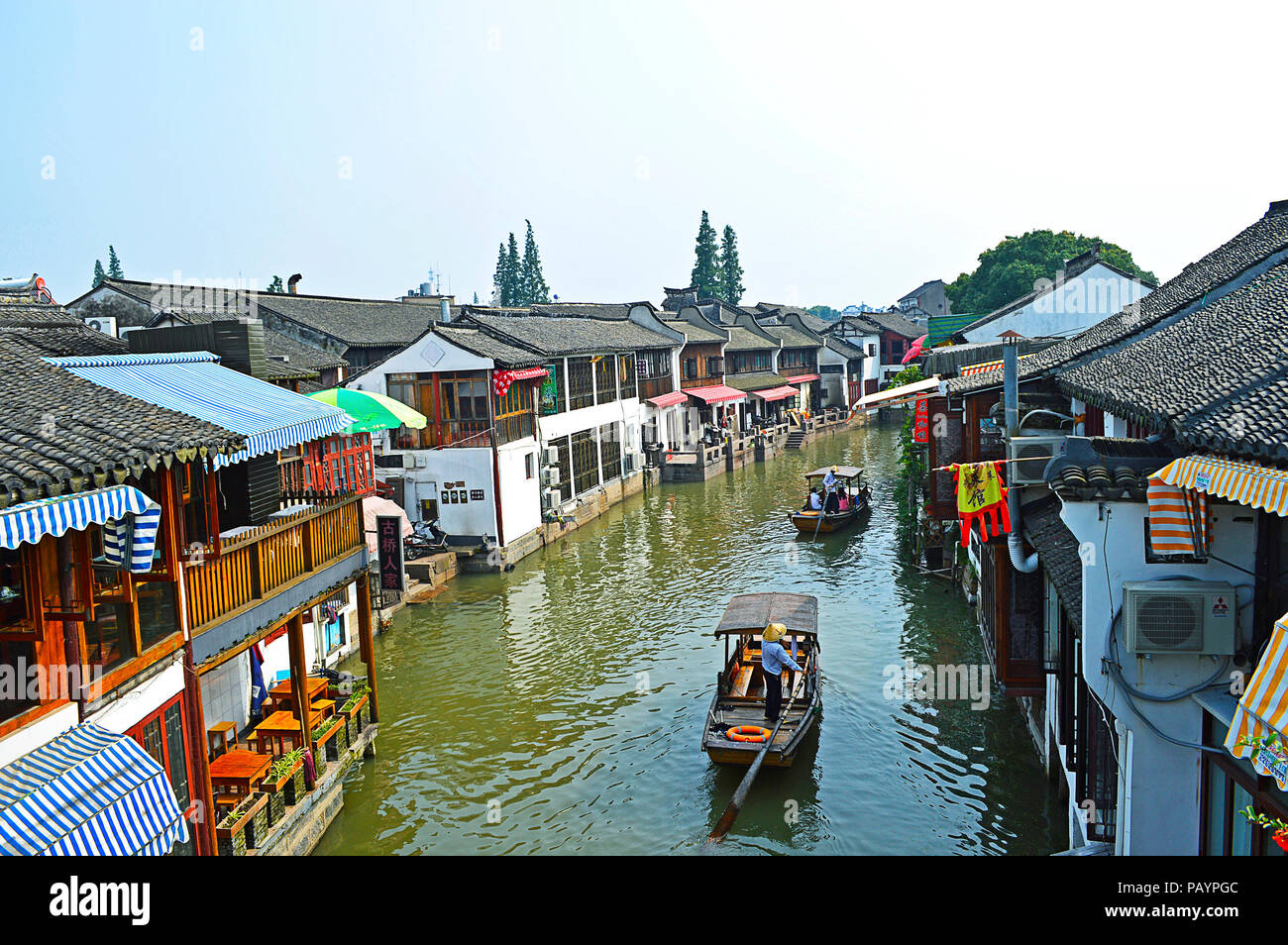 Shanghai Zhujiajiao Wasser Stadt, China, Juli 2015. Zwei Boote mit Schiffer und passieren die Touristen die Häuser auf dem Wasser Stadt Kanal in einem sonnigen Tag. Stockfoto