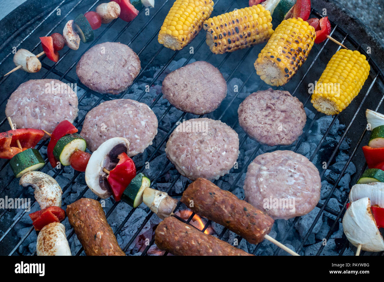 Burger, Lamm Kebab und Spieße mit Gemüse kochen in einem Grill. Stockfoto